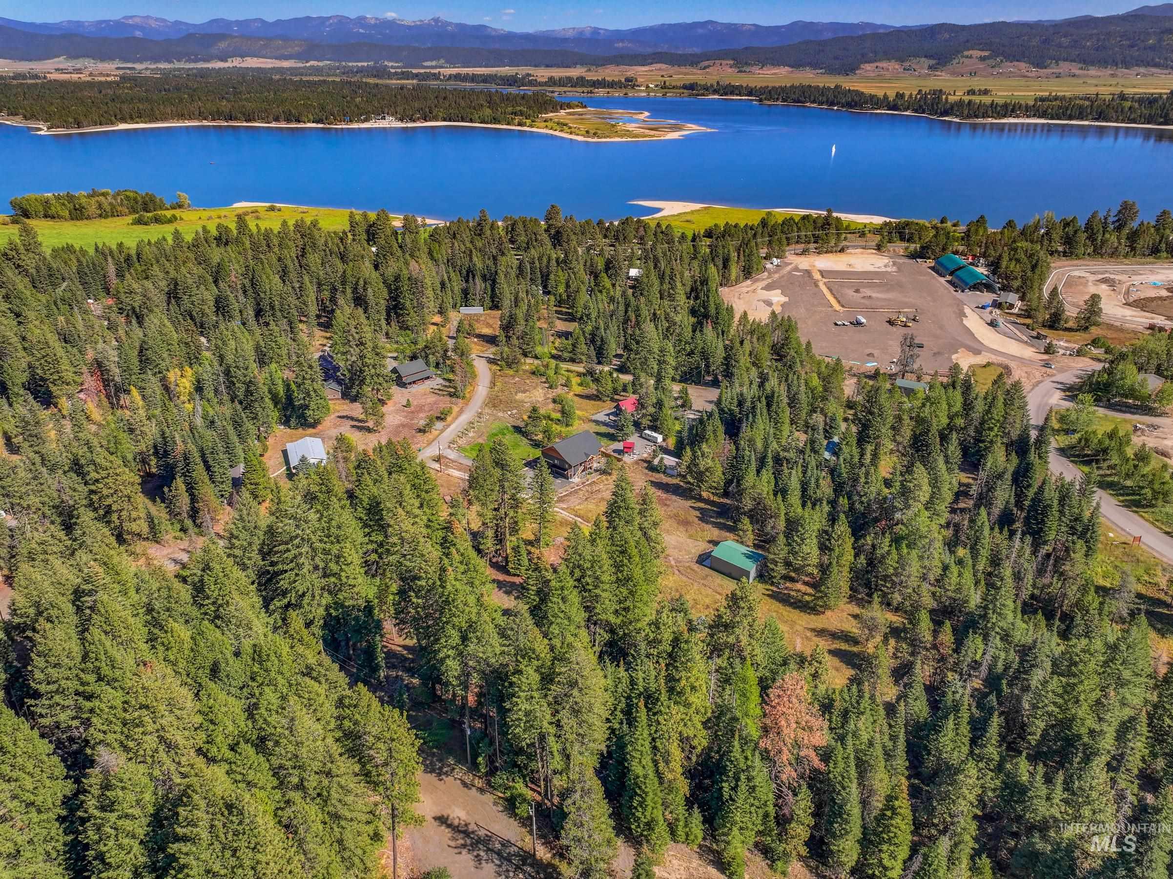 Aerial overview of property's location featuring a water and mountain view and a forest