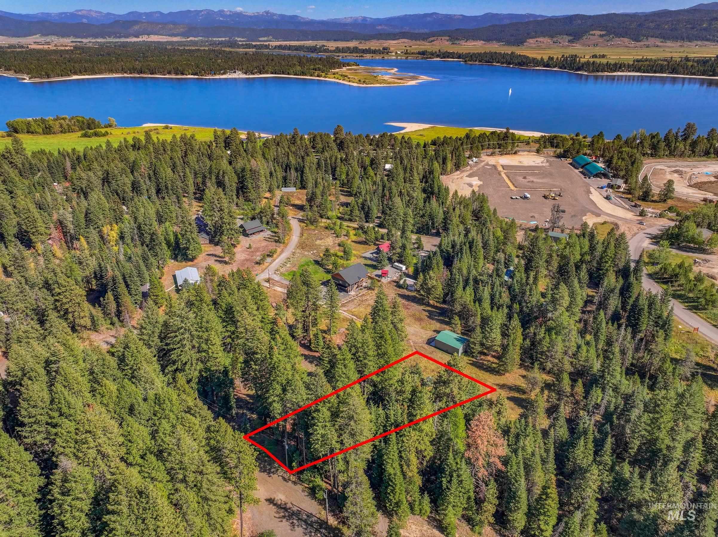 Aerial view of property's location featuring a nearby body of water and mountain view and property parcel outlined
