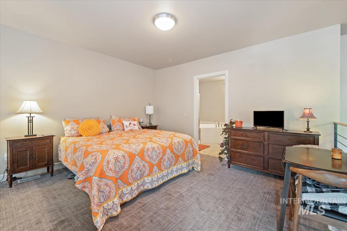 Bedroom with carpet floors and connected bathroom