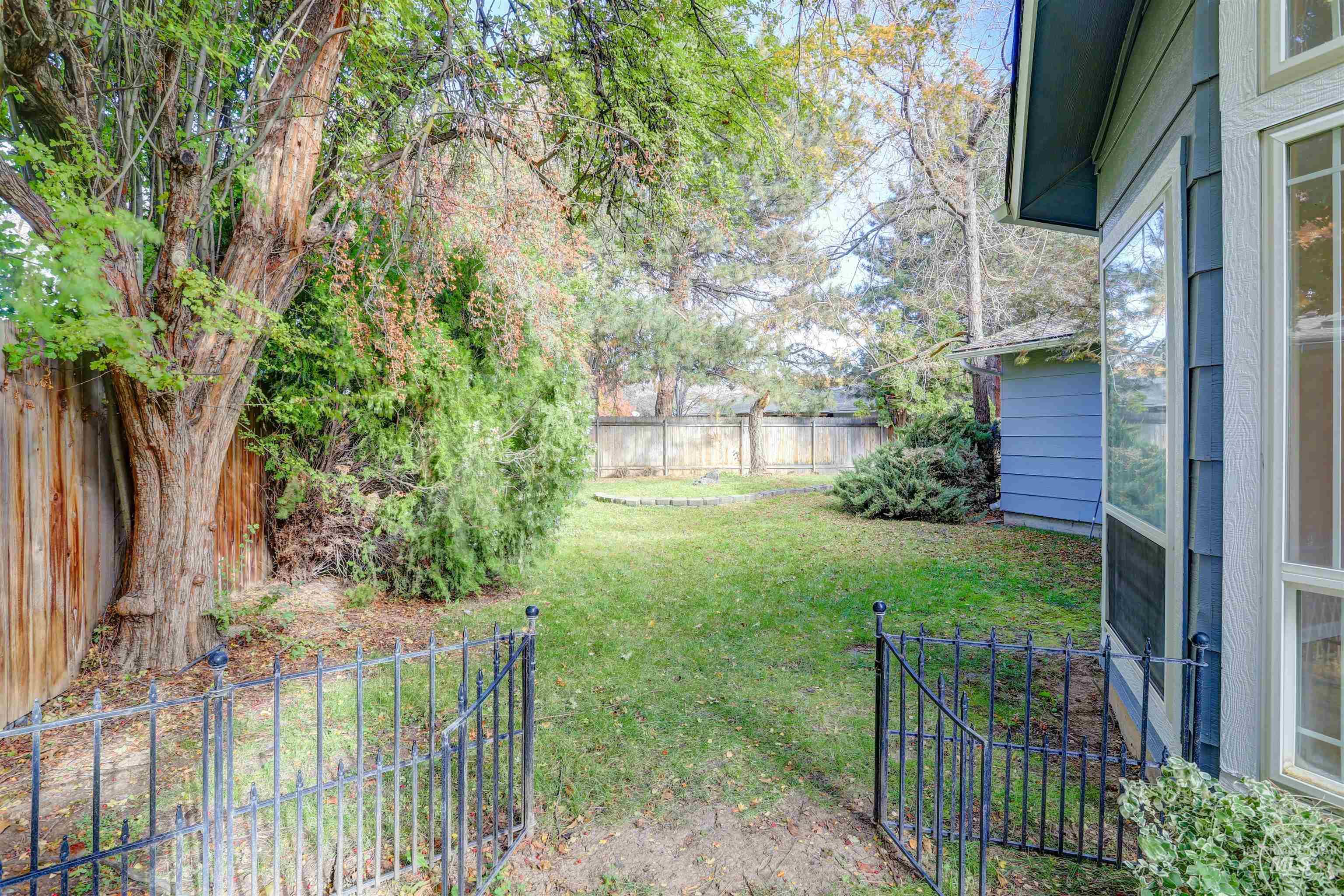 Fenced backyard featuring view of wooded area