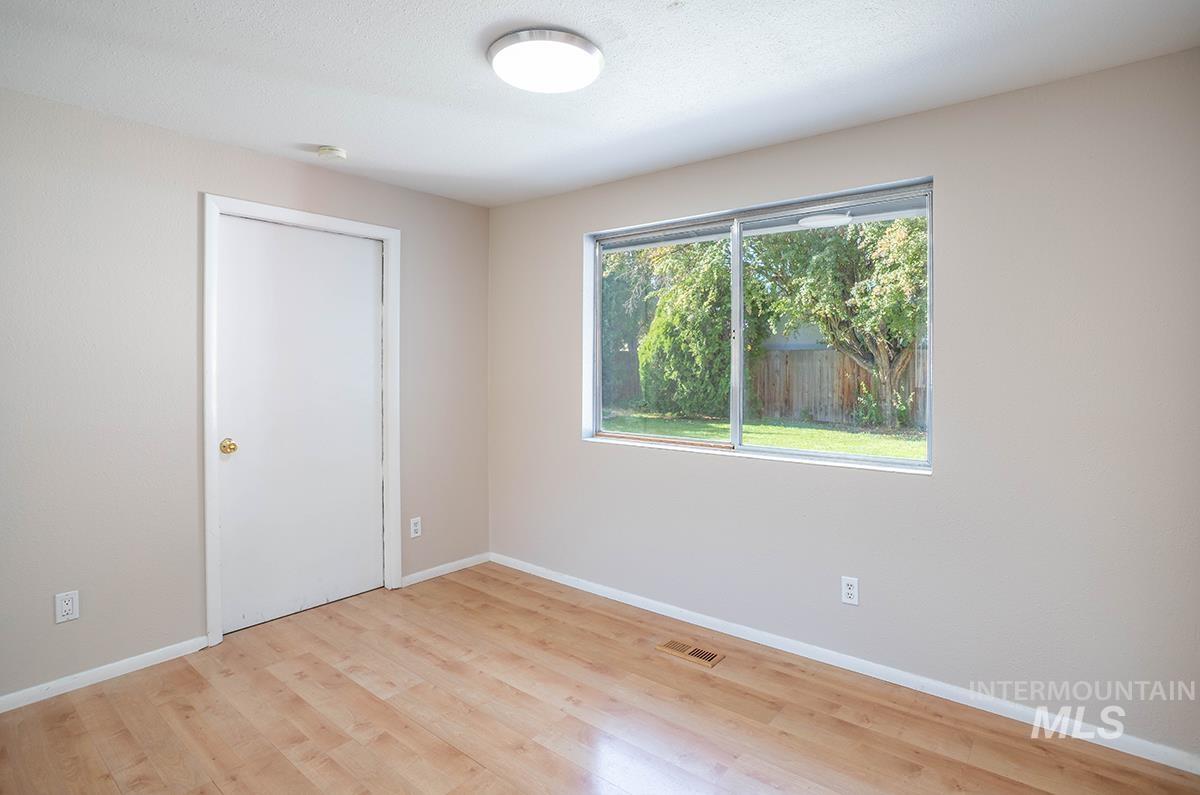Empty room with baseboards and light wood-style flooring
