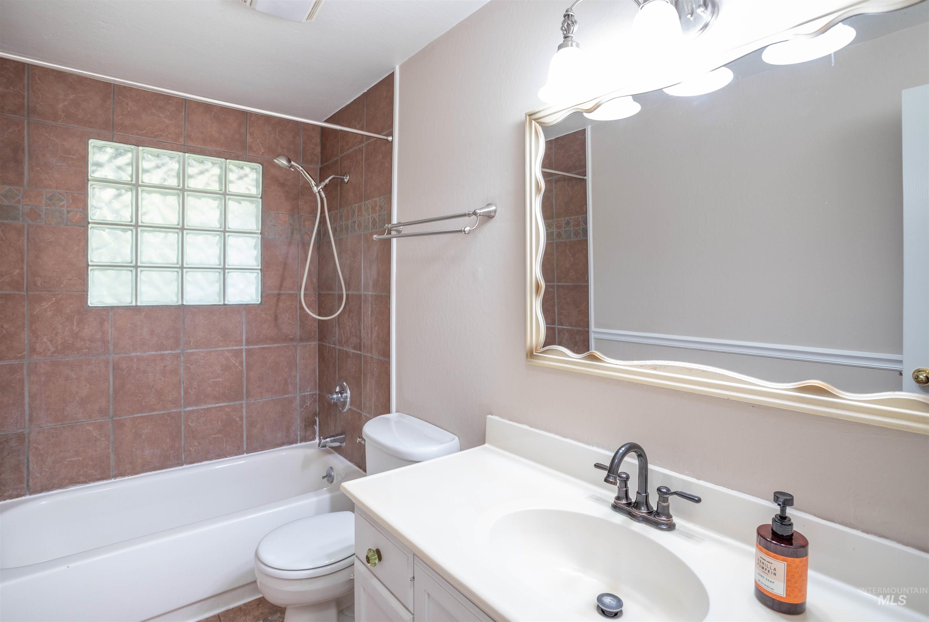 Bathroom with vanity and shower / washtub combination