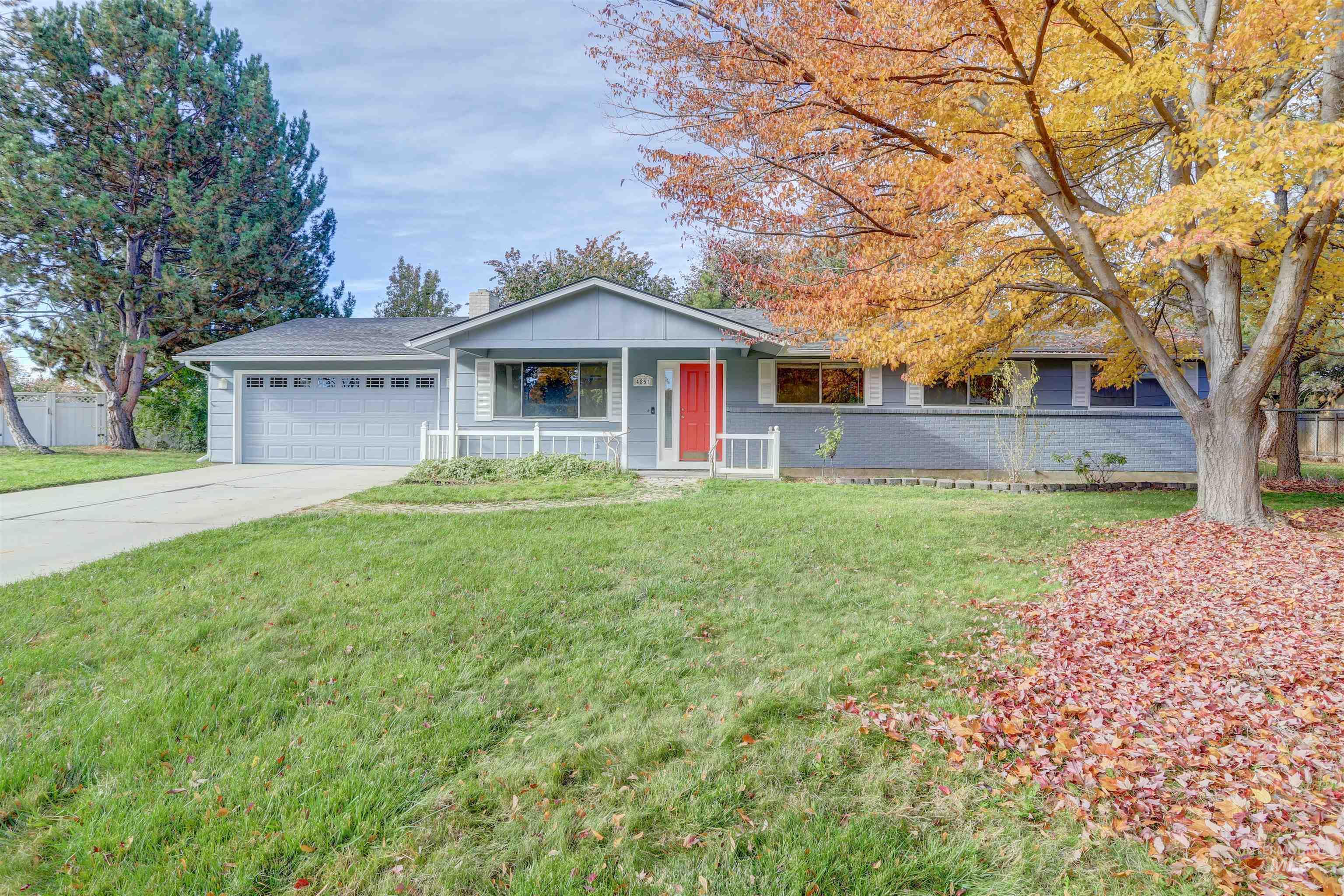 Ranch-style house featuring a porch, concrete driveway, an attached garage, and board and batten siding