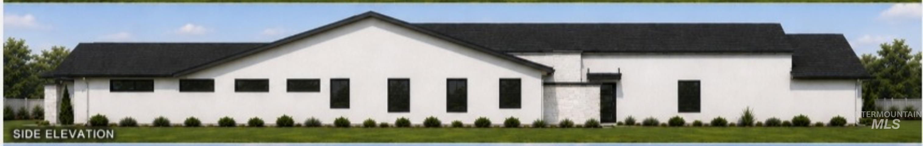White stucco exterior featuring a dark asphalt shingle roof, multiple dark-framed windows, and neatly trimmed shrubbery