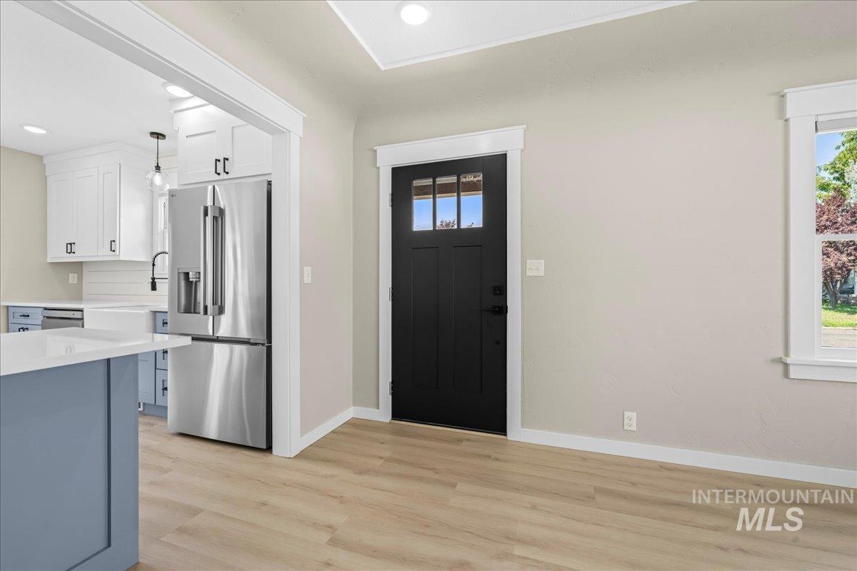 Entrance foyer with light wood-style flooring and recessed lighting