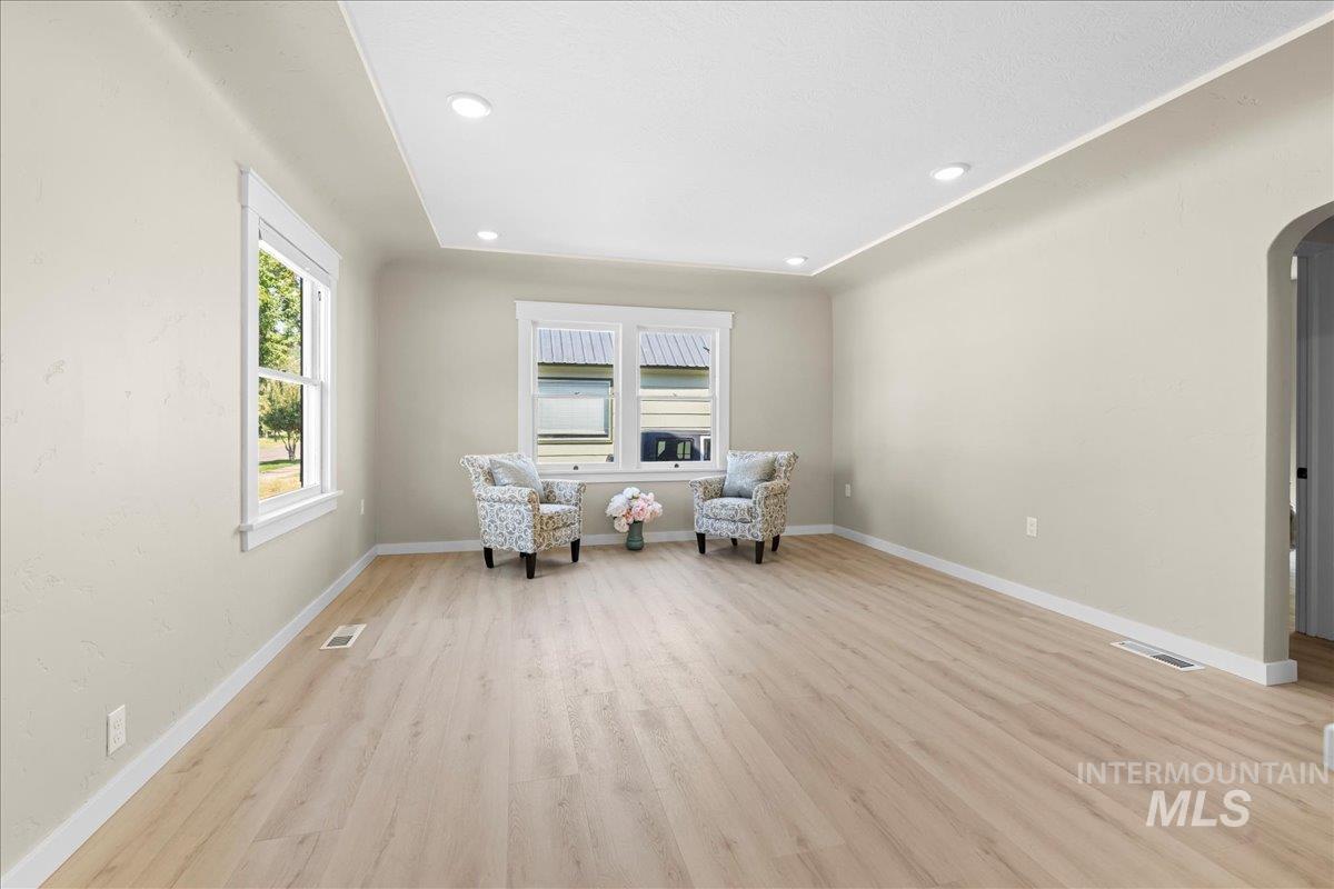 Sitting room featuring arched walkways, light wood-style flooring, and recessed lighting