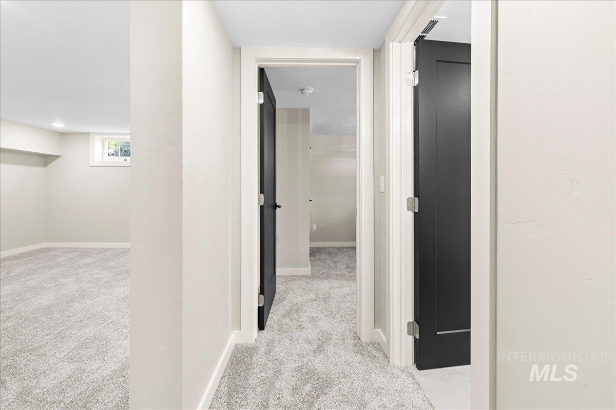 Corridor with light carpet and baseboards