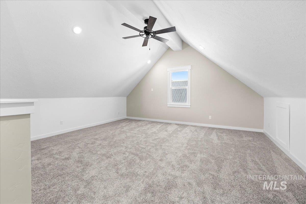 Bonus room featuring light carpet and a ceiling fan