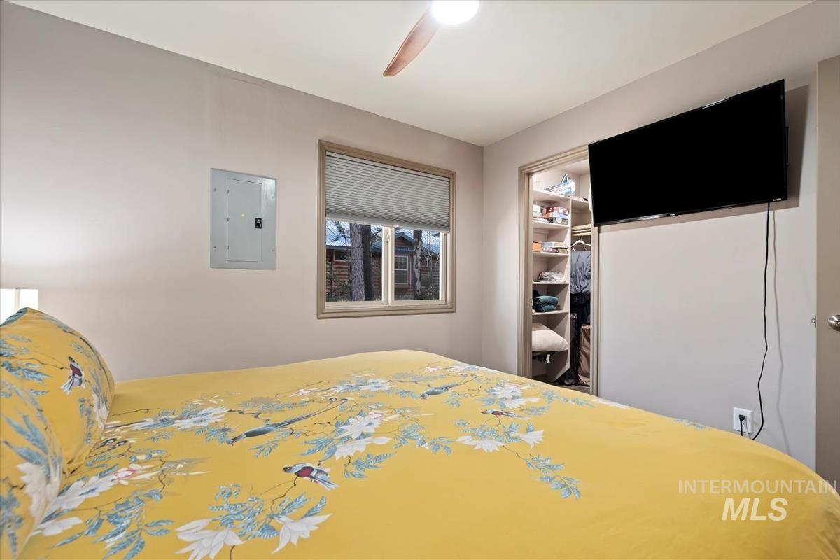 Bedroom featuring electric panel, ceiling fan, and a closet