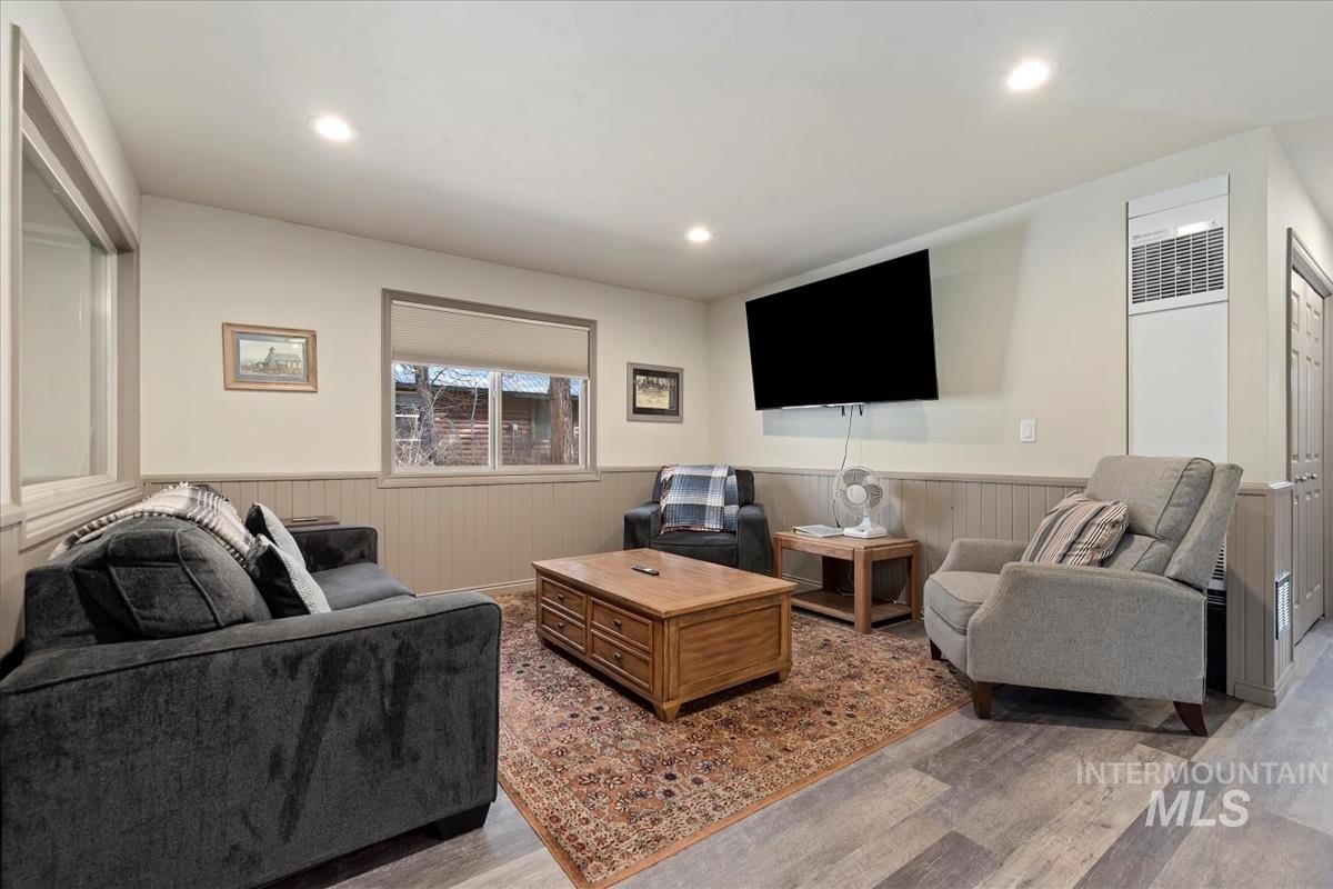 Living room featuring light wood finished floors, recessed lighting, and a wainscoted wall