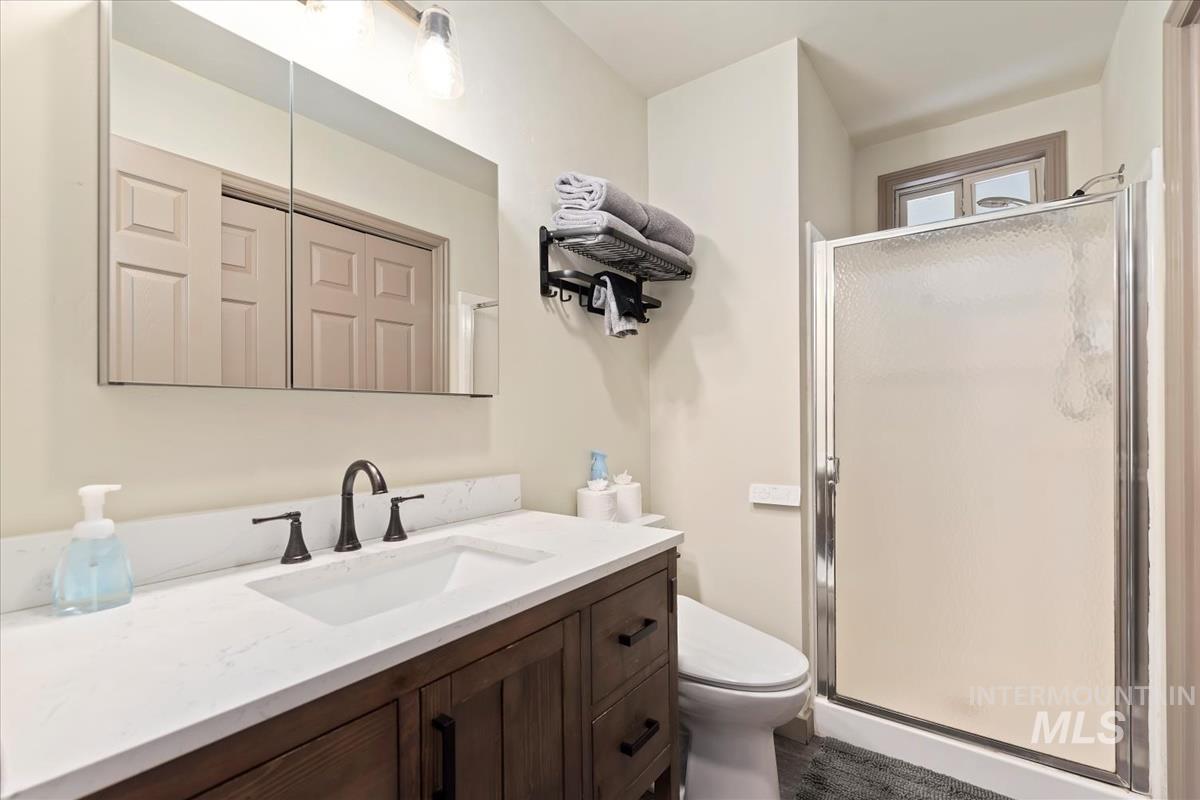Full bath with a shower stall and vanity