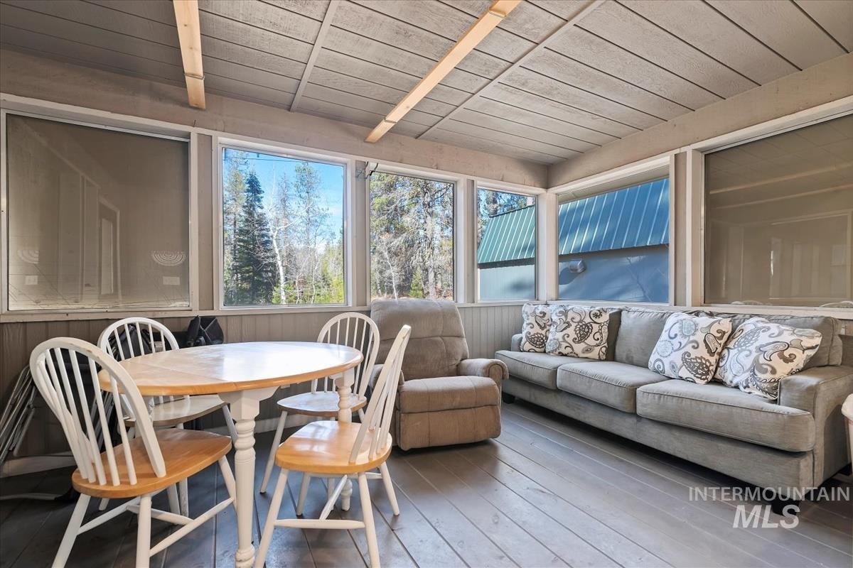 Sunroom / solarium with hardwood / wood-style floors and wooden ceiling