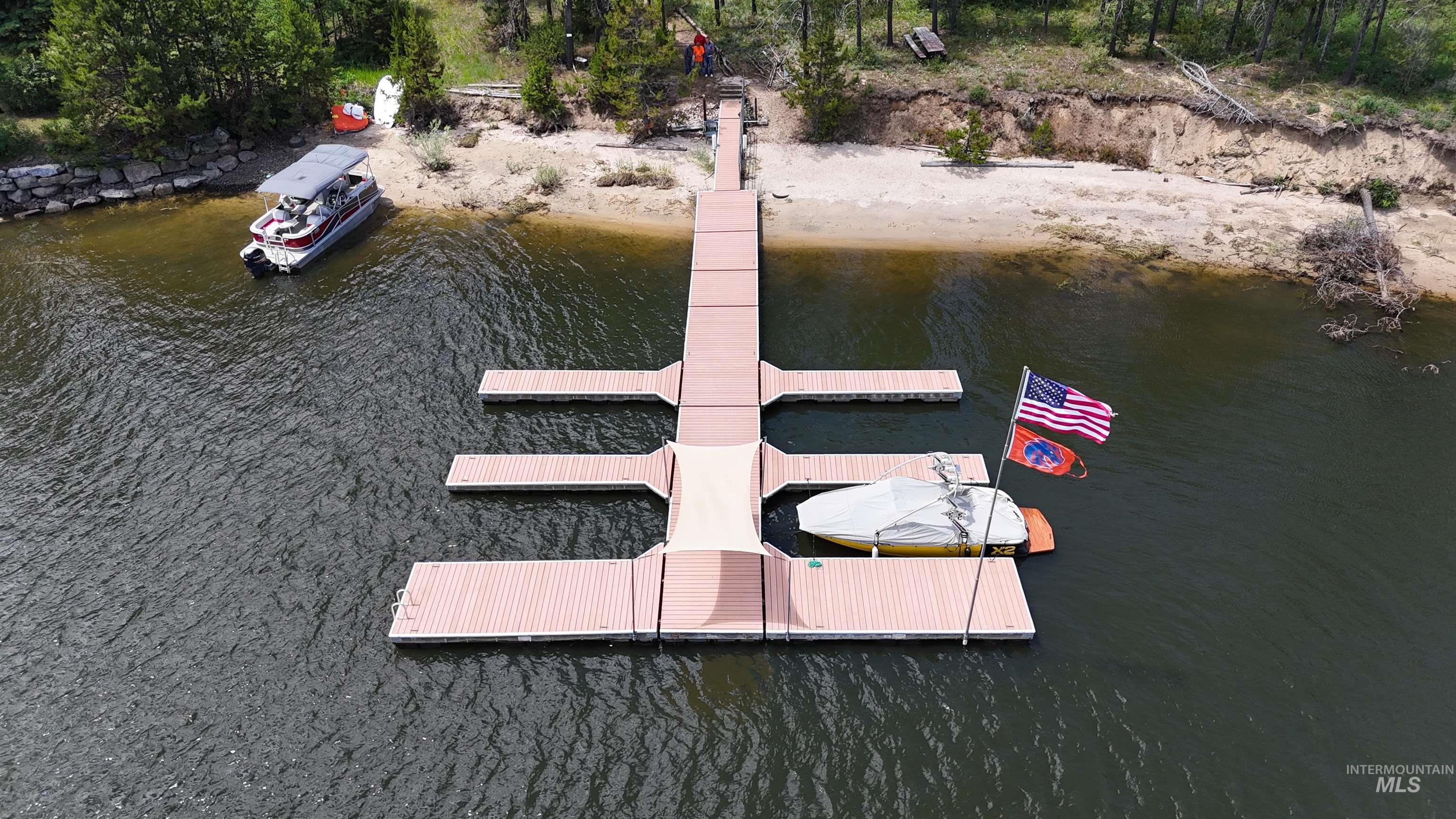 Expansive dock system featuring a wide main pier, multiple mooring slips, and direct access to a sandy shoreline