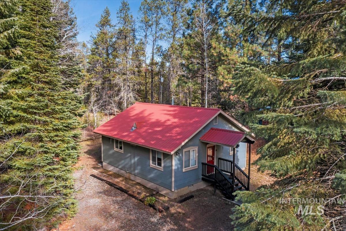 View of side of home featuring a metal roof and a porch
