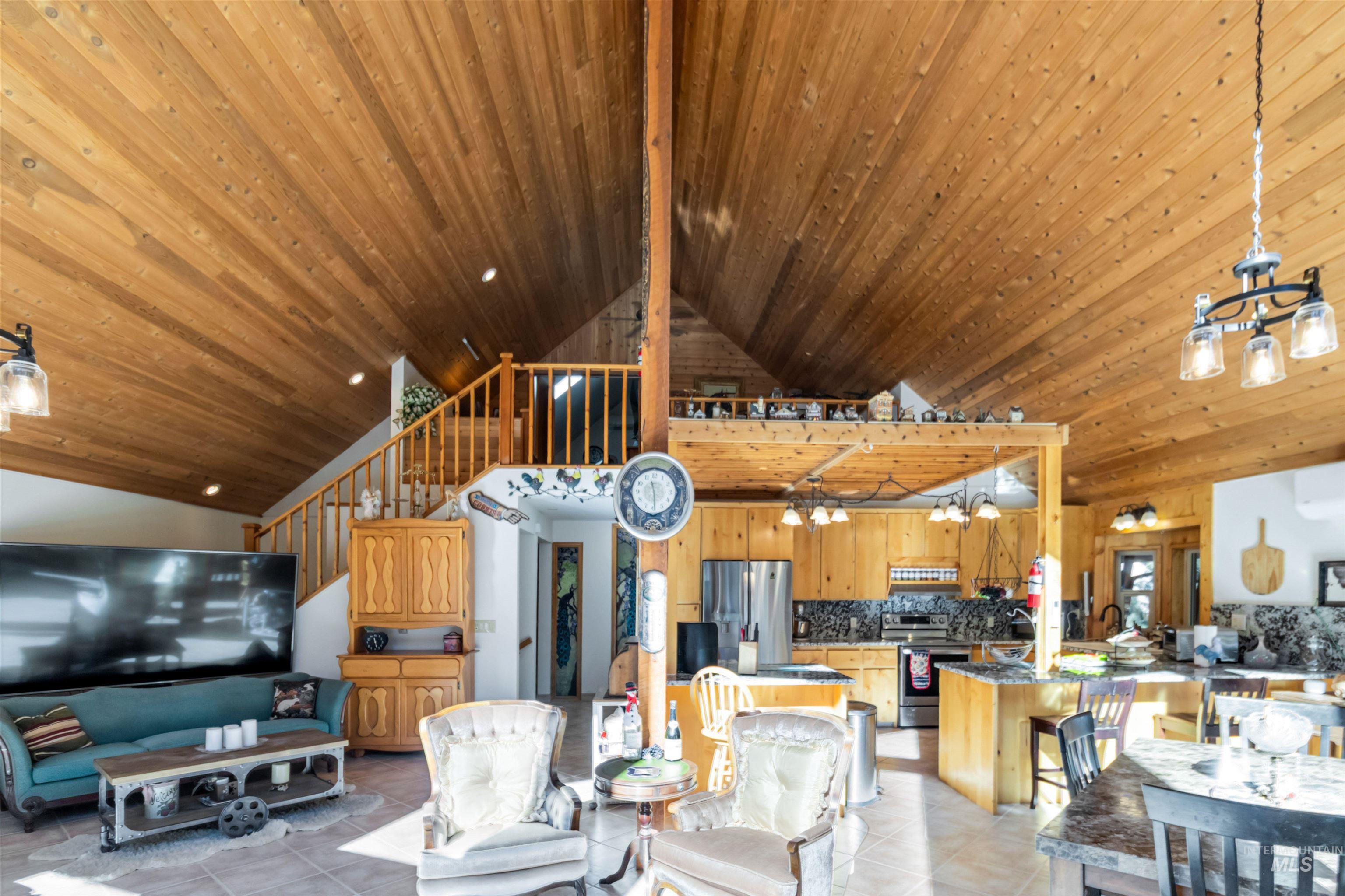 Dining room featuring a chandelier, high vaulted ceiling, stairs, wooden ceiling, and light tile patterned floors