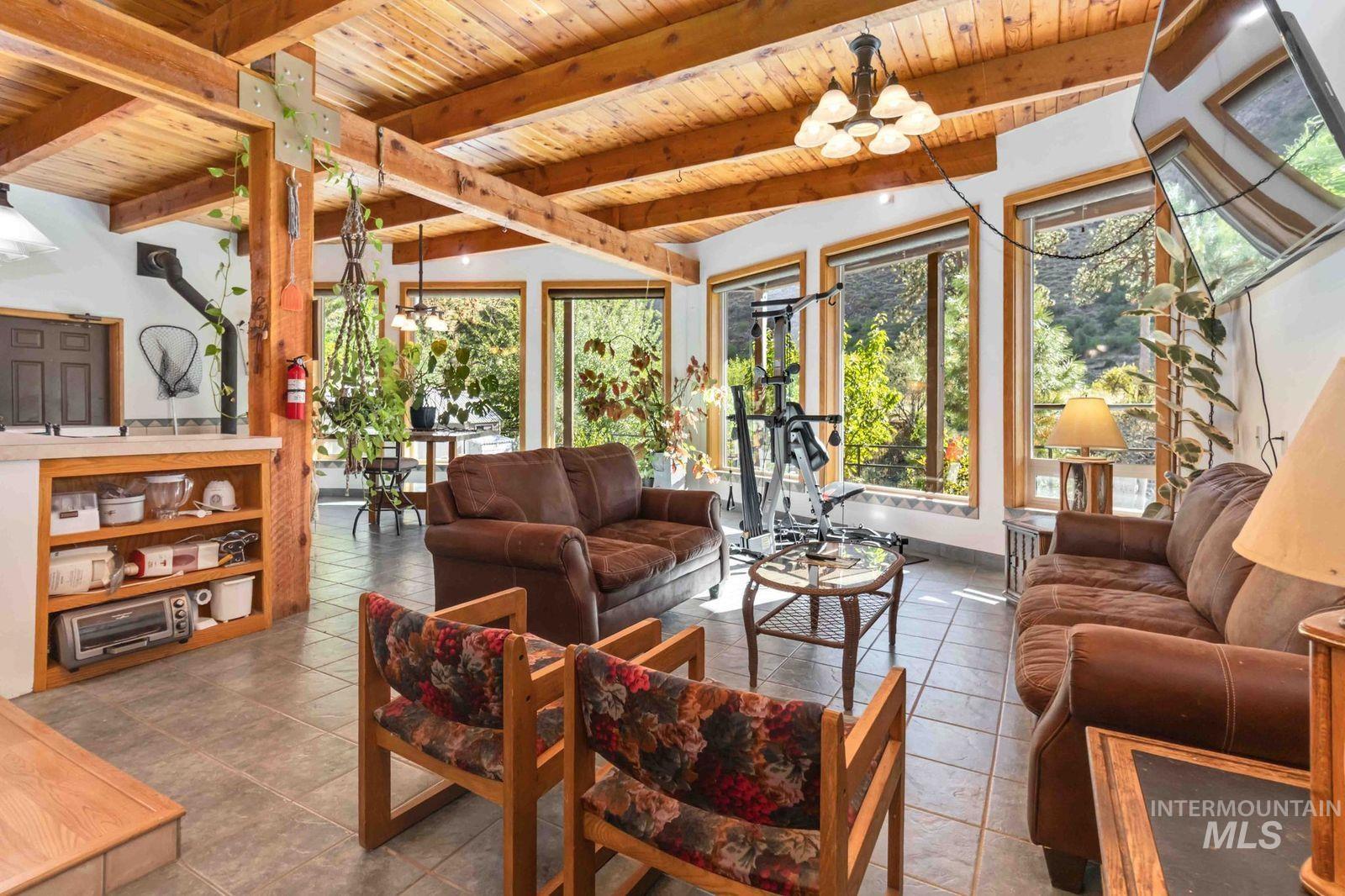 Sunroom / solarium featuring a chandelier and beam ceiling