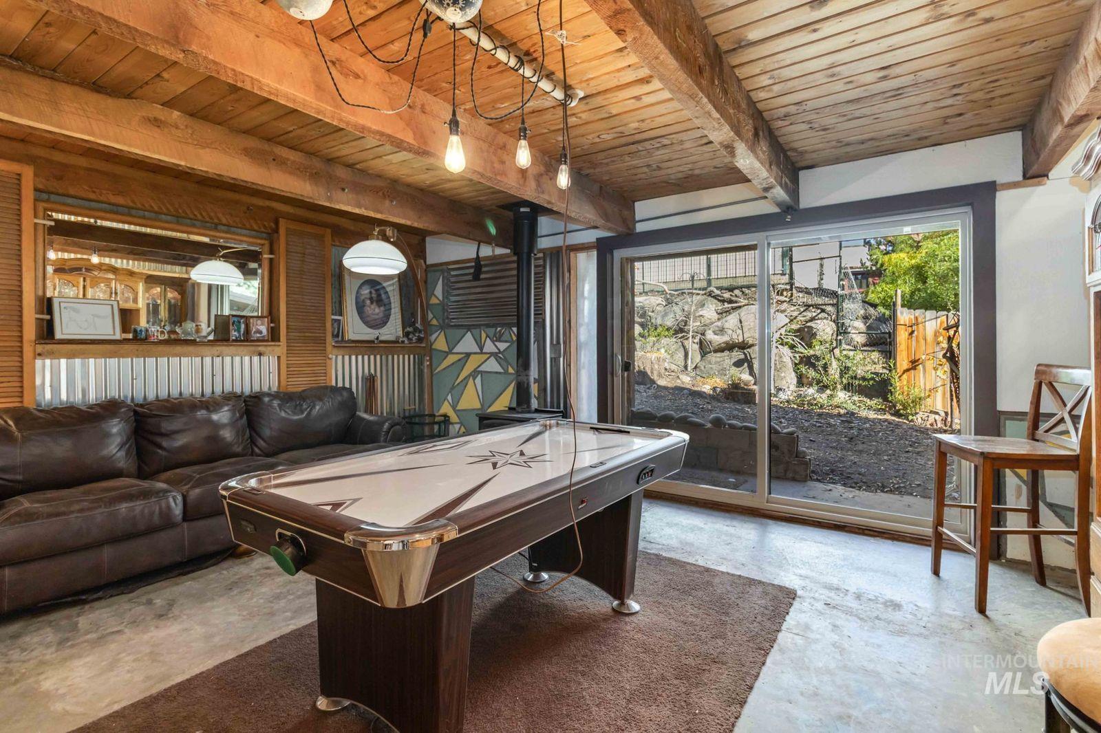 Playroom featuring concrete floors, a wooden ceiling with exposed beams, and pool table