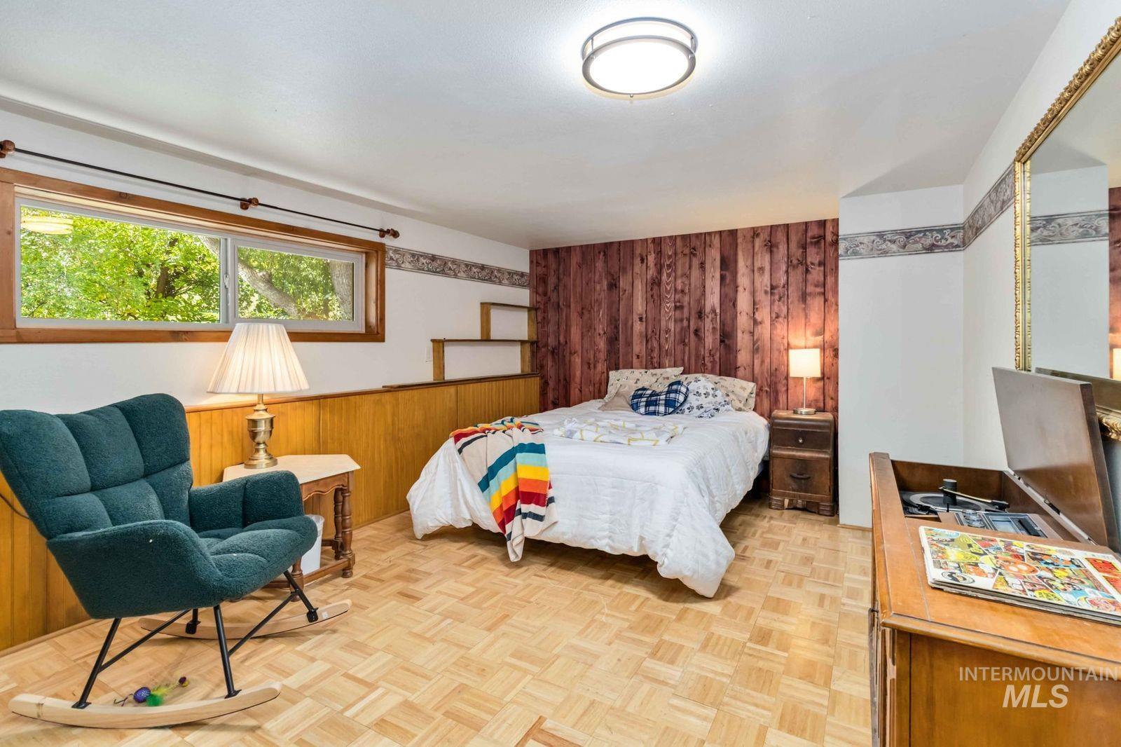 Bedroom with wooden walls and wainscoting