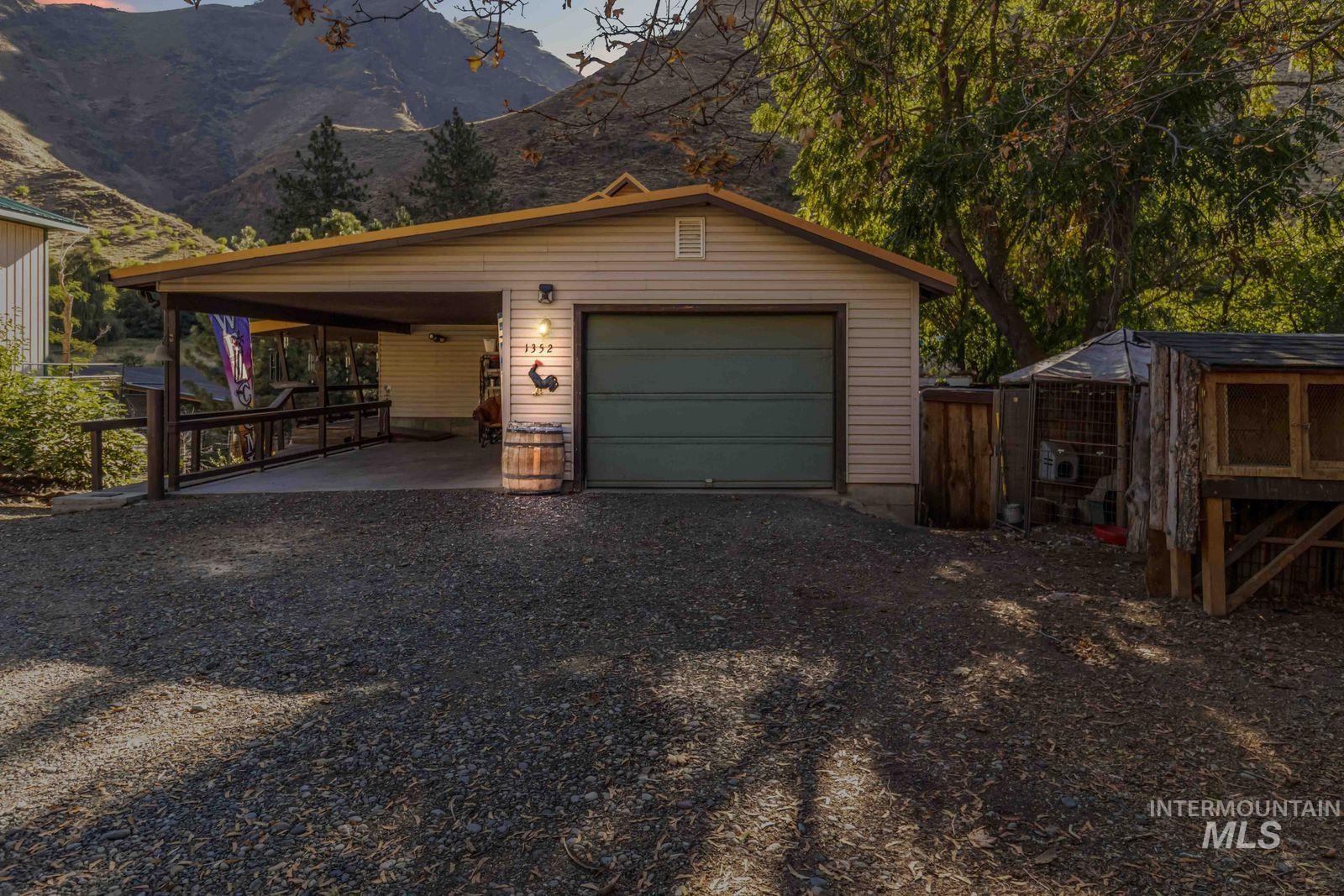 Garage with driveway, a carport, and a mountain view