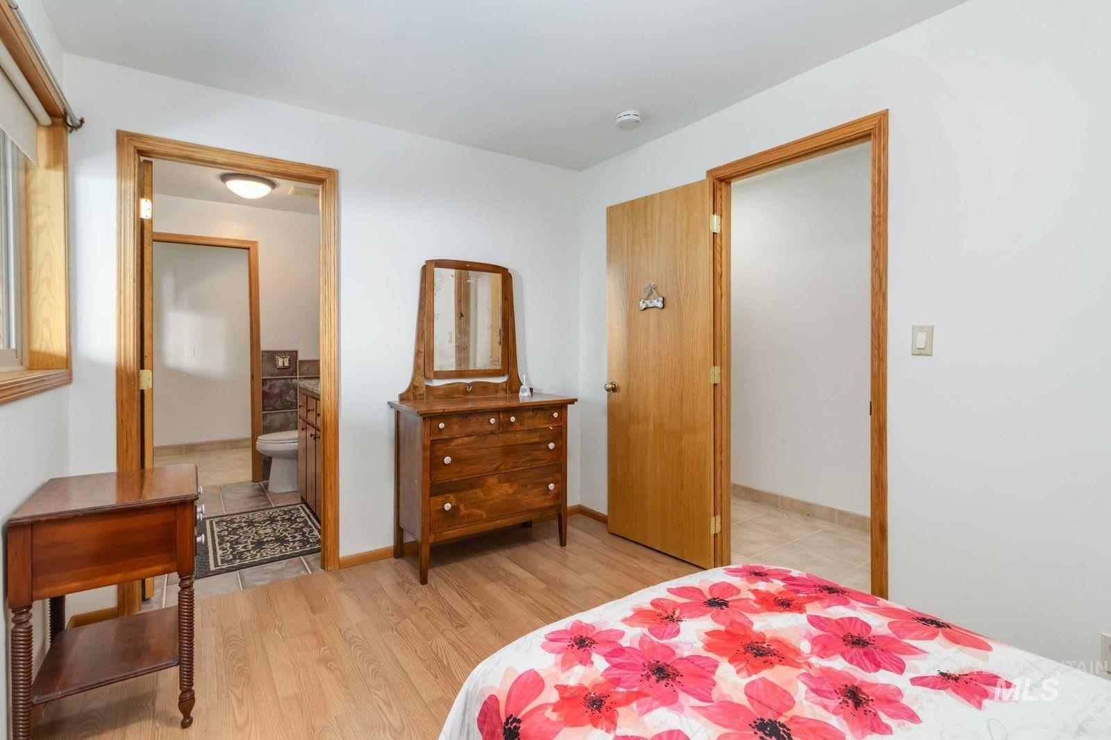 Bedroom featuring light wood-style flooring and connected bathroom