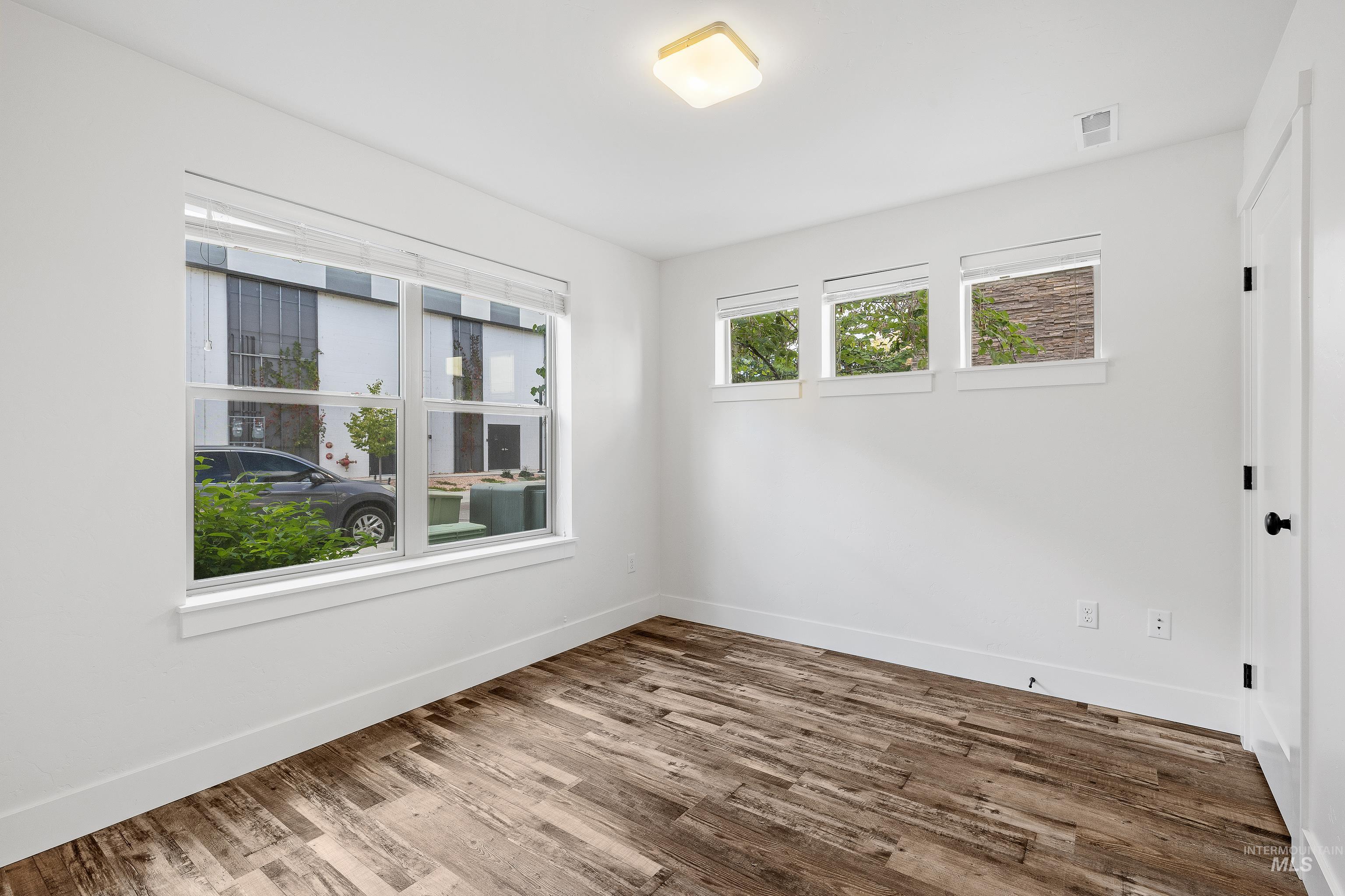 Spare room with dark wood finished floors and baseboards