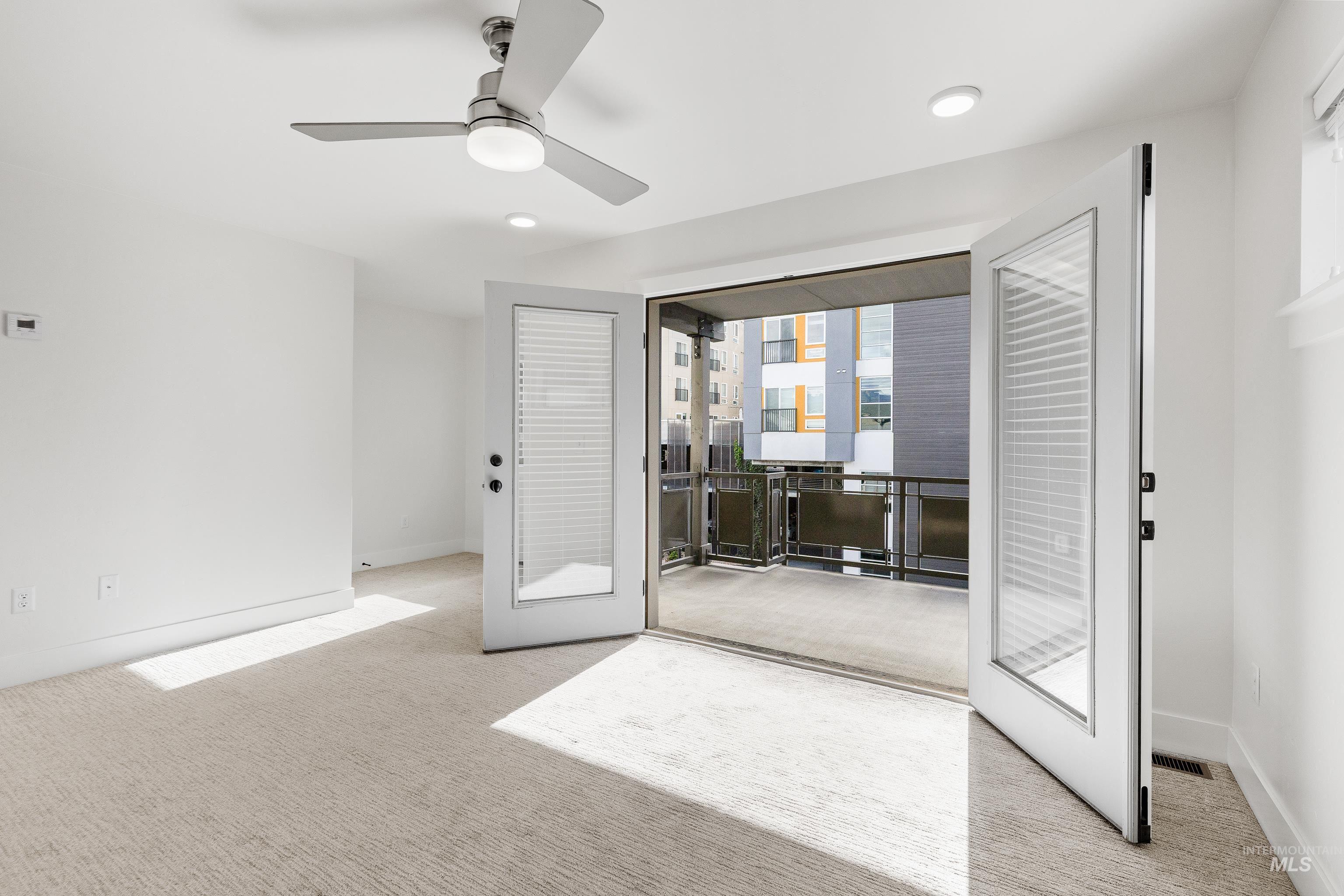 Bedroom with light colored carpet, ceiling fan, recessed lighting, and french doors