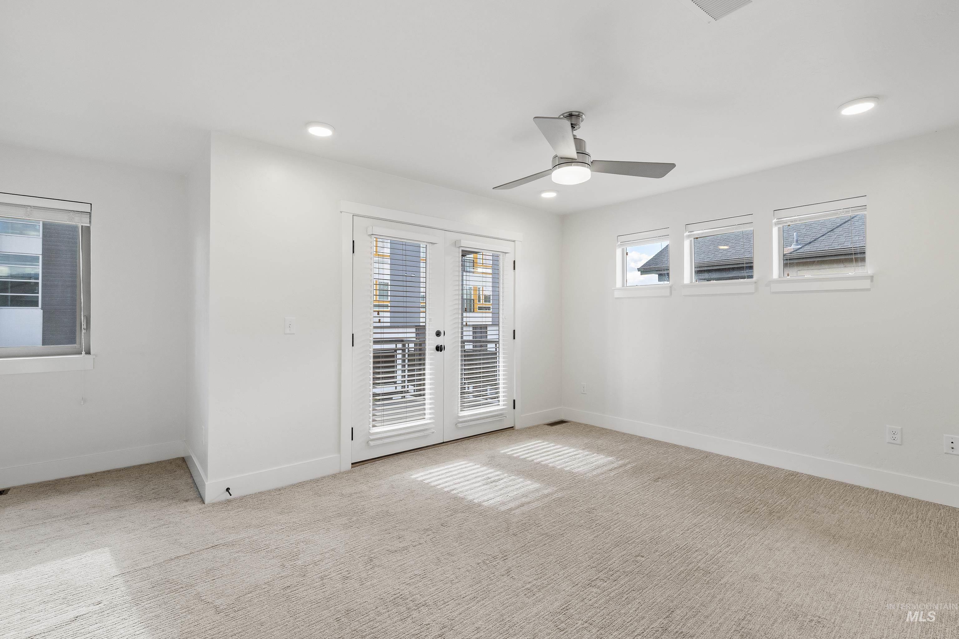 Empty room featuring light colored carpet, recessed lighting, and ceiling fan