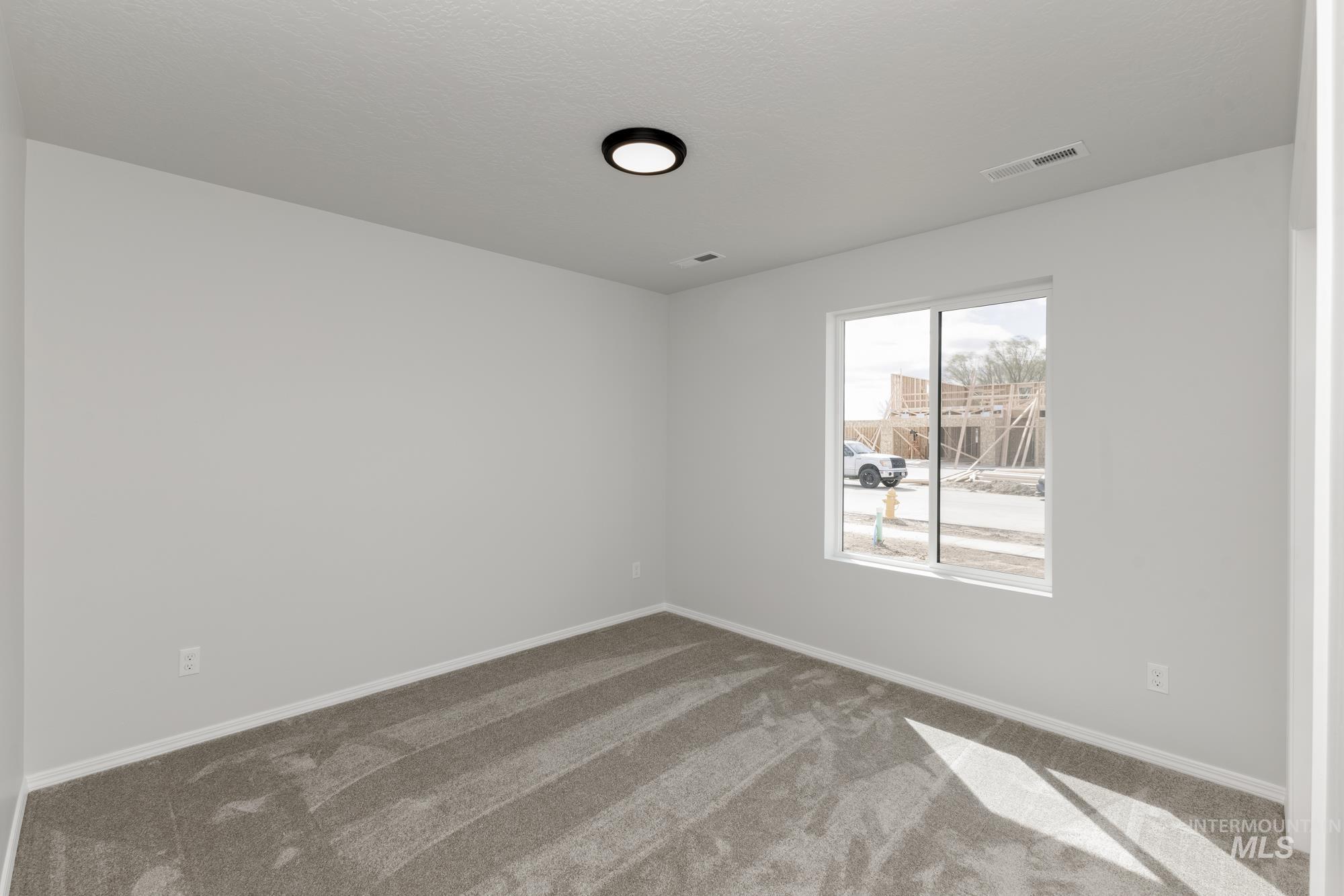 Carpeted spare room with baseboards