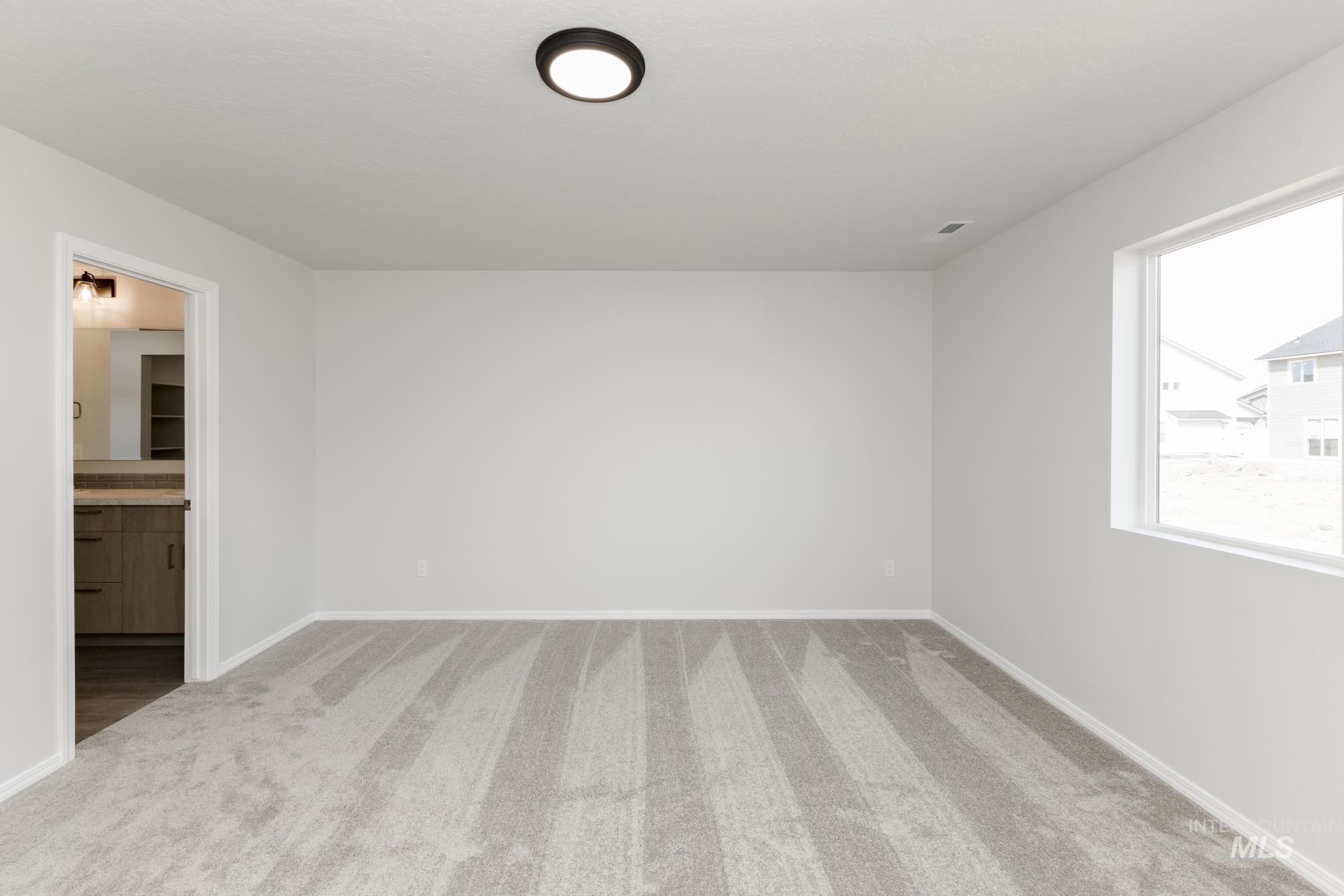 Unfurnished bedroom with carpet flooring and connected bathroom