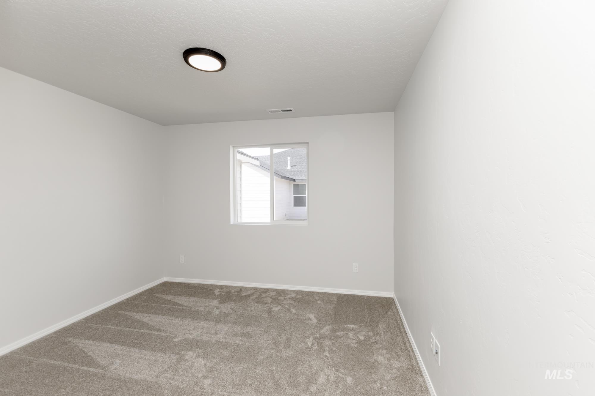 Unfurnished room with carpet flooring and a textured ceiling