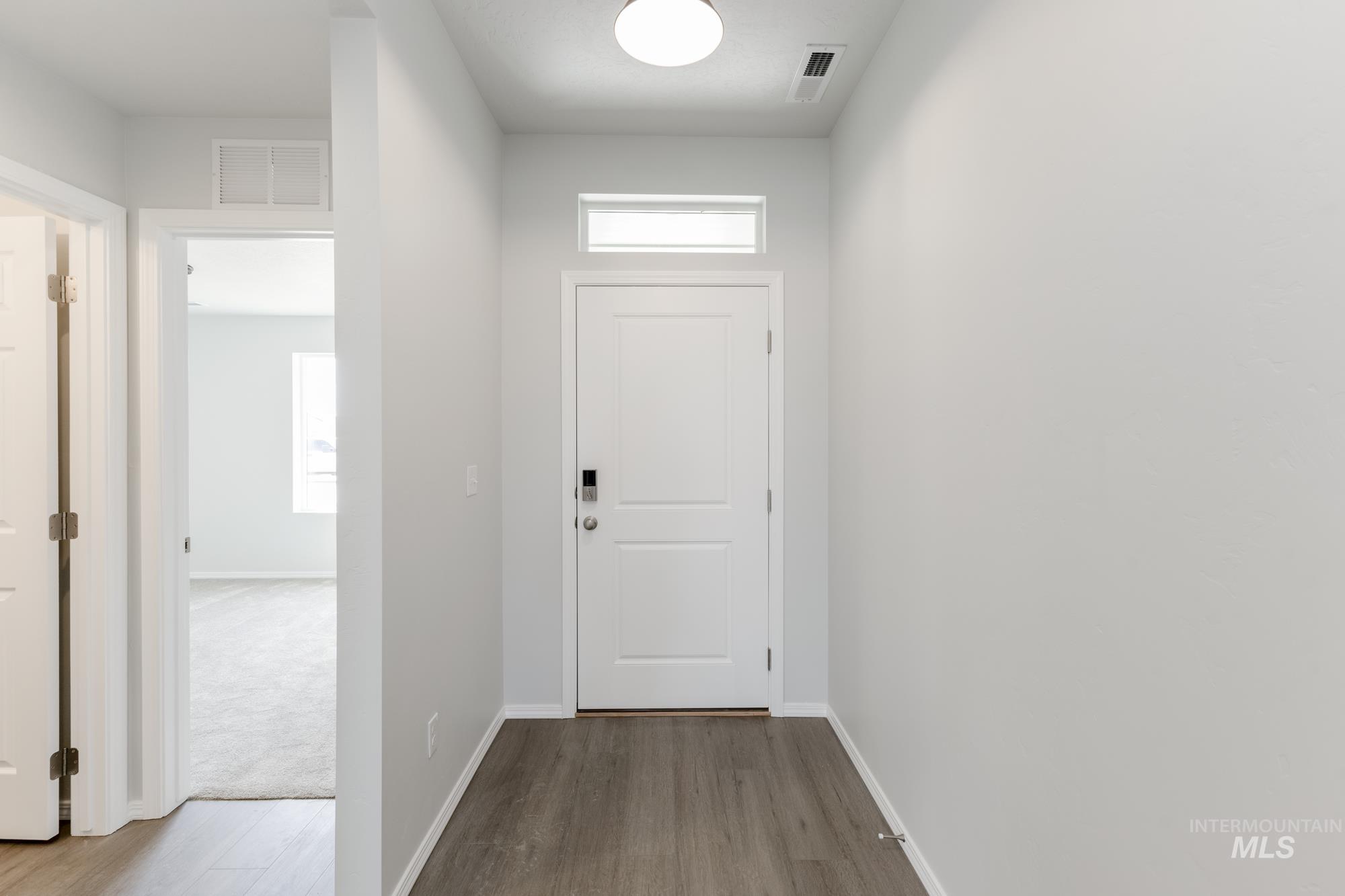 Entryway featuring baseboards and wood finished floors