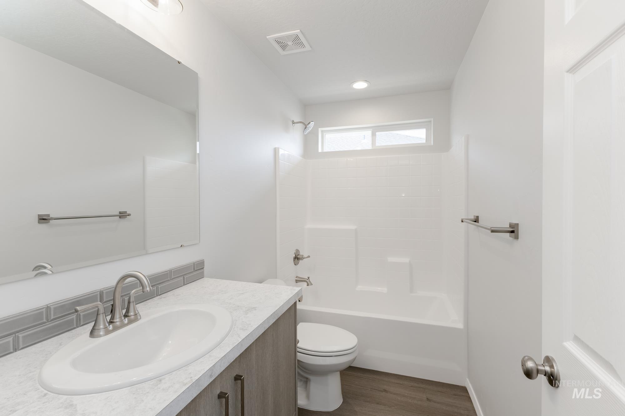 Full bathroom featuring vanity, shower / bathtub combination, and dark wood-style flooring