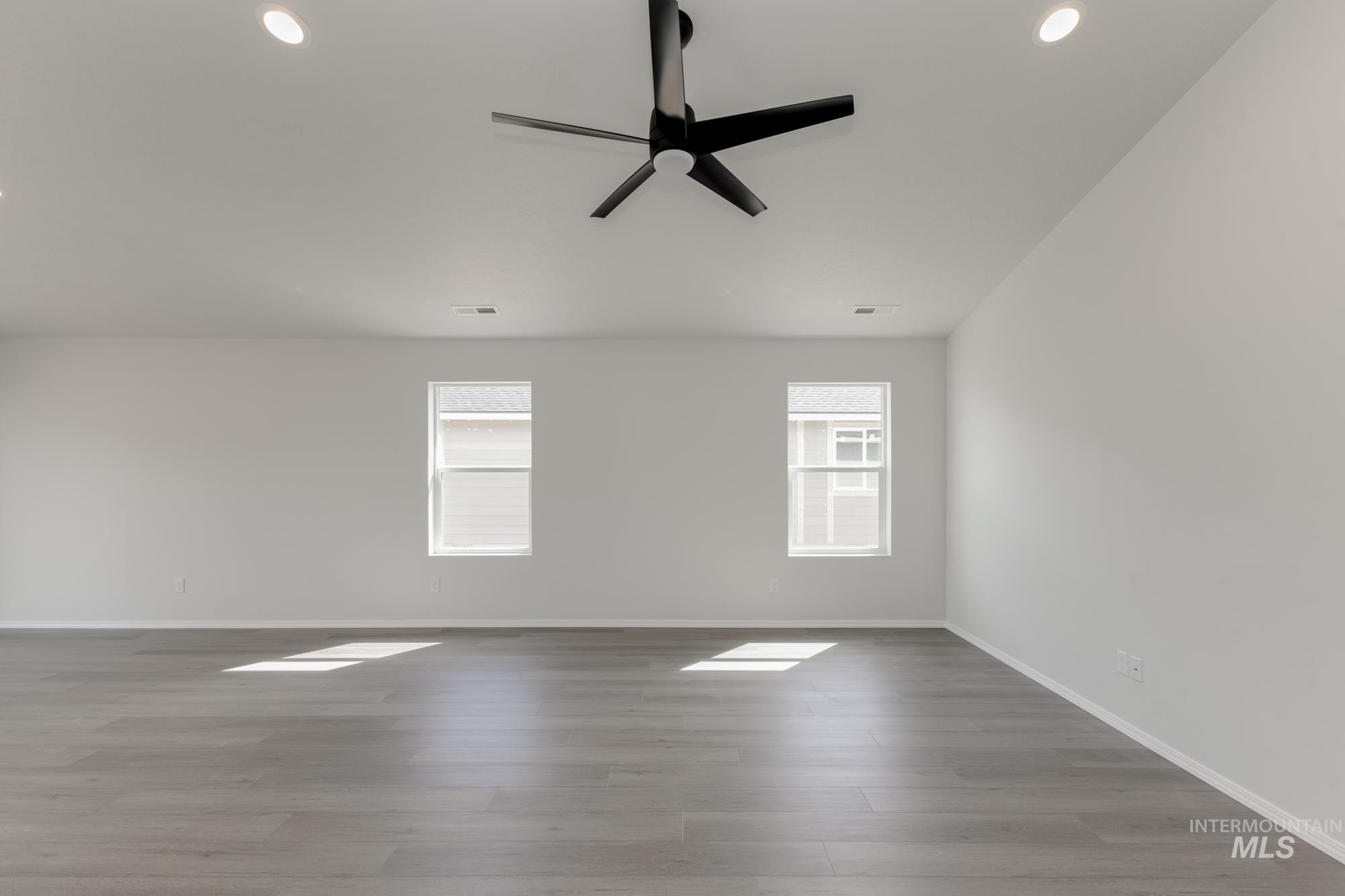 Empty room with light wood finished floors, ceiling fan, and recessed lighting
