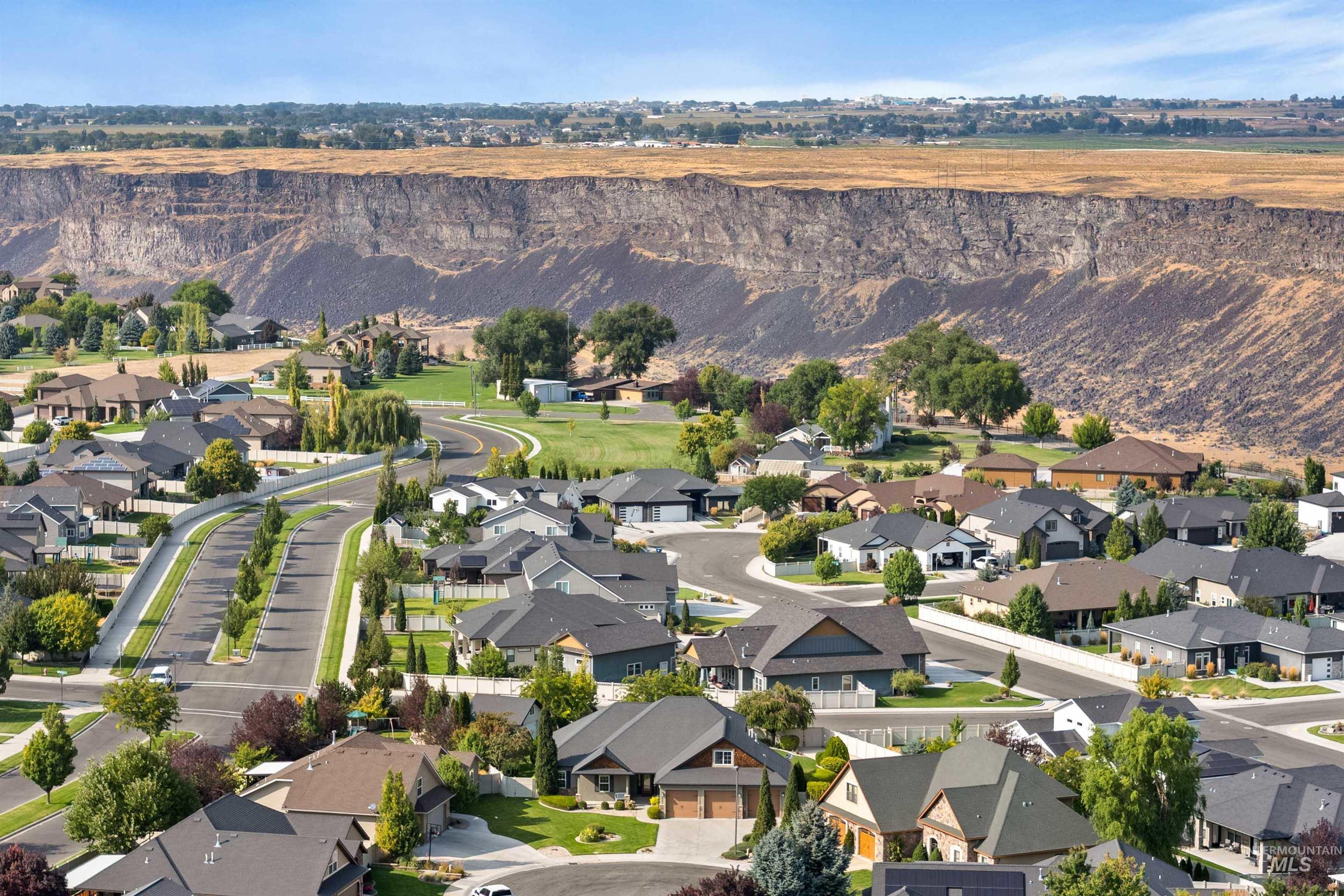 Aerial view of property and surrounding area with nearby suburban area