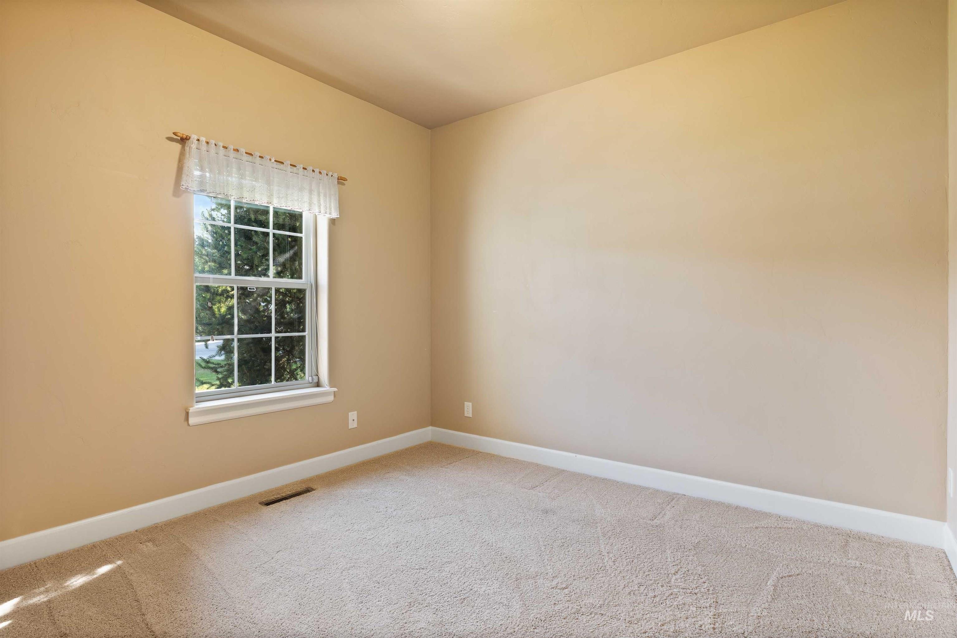 Carpeted spare room with baseboards