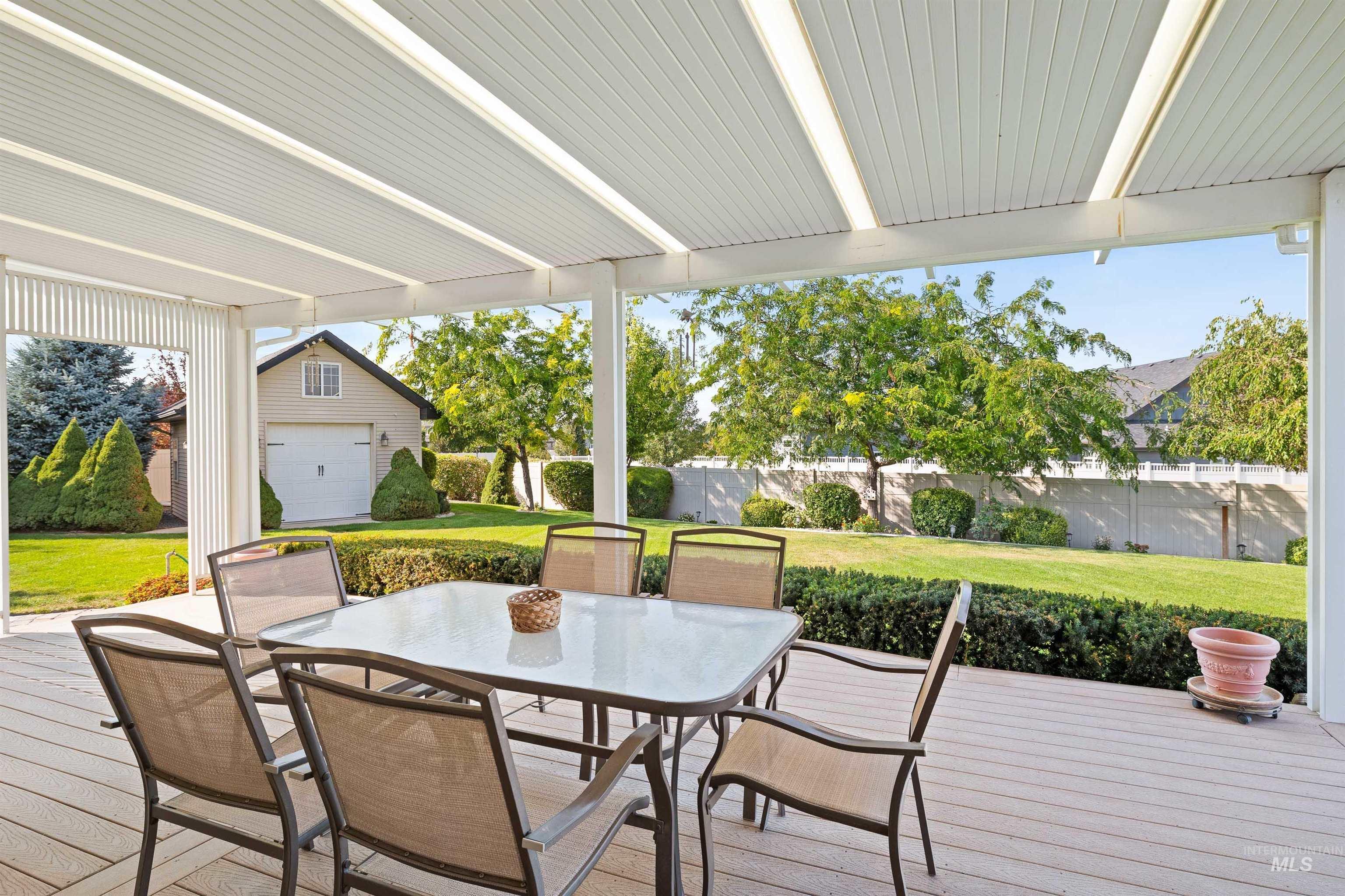 Wooden terrace with outdoor dining area and an outdoor structure