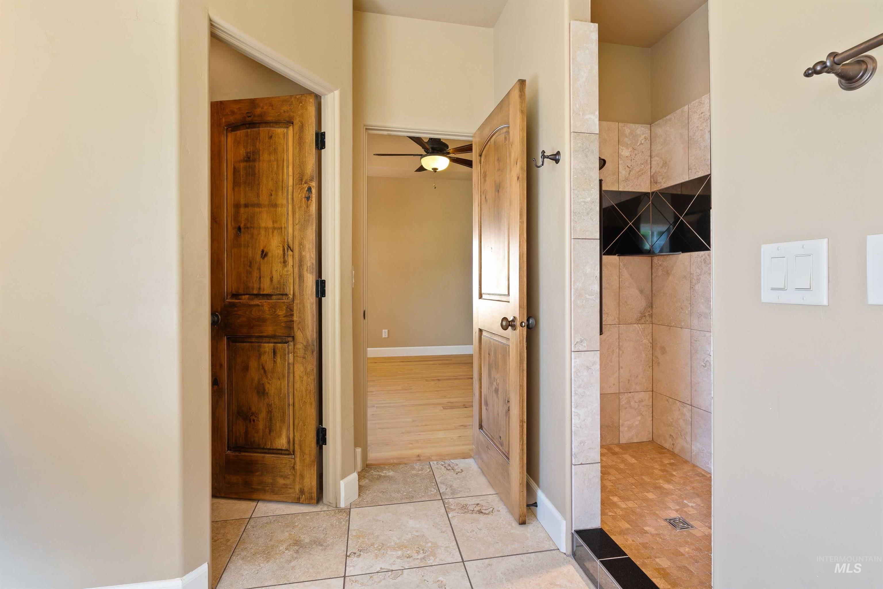 Bathroom featuring walk in shower, tile patterned floors, and a ceiling fan