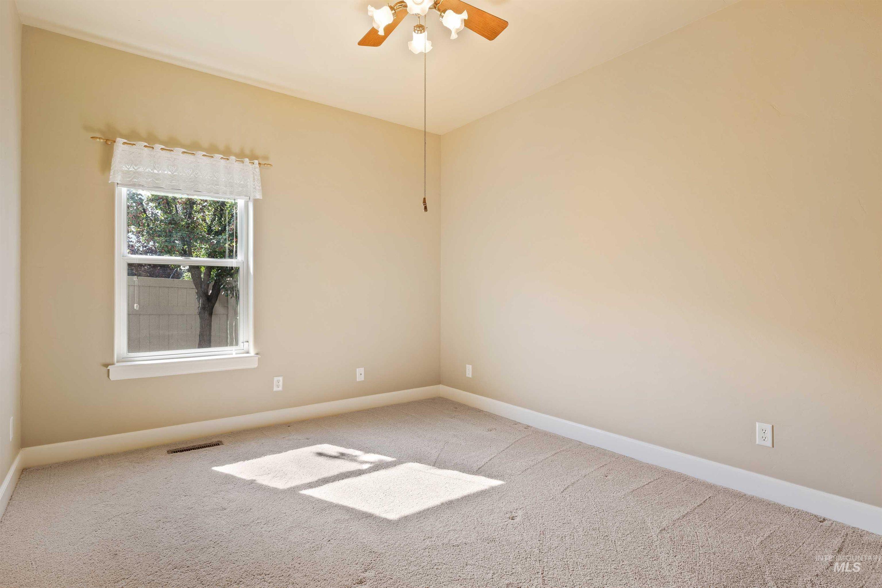 Empty room with carpet flooring and ceiling fan