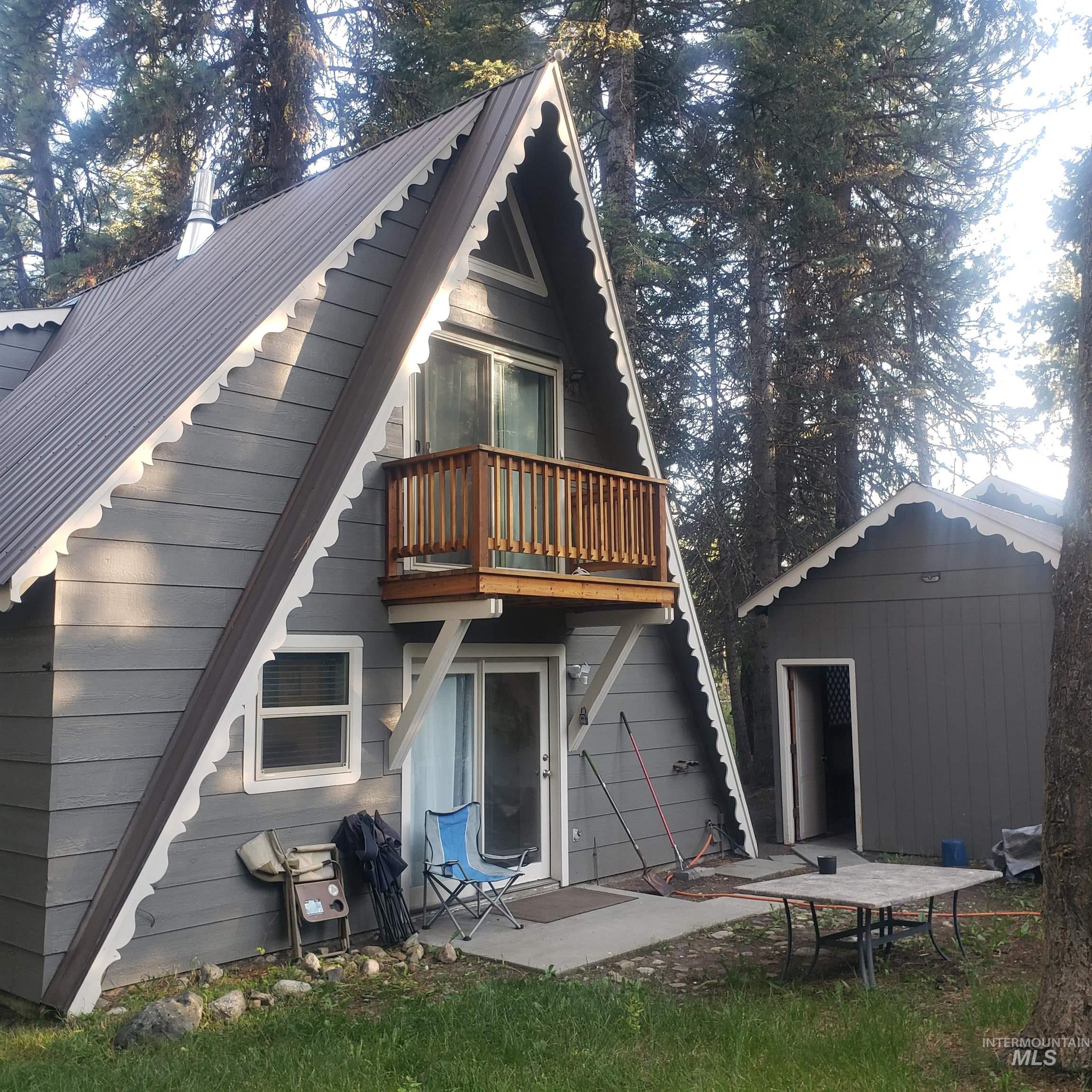 Back of property featuring a patio, an outbuilding, and a metal roof