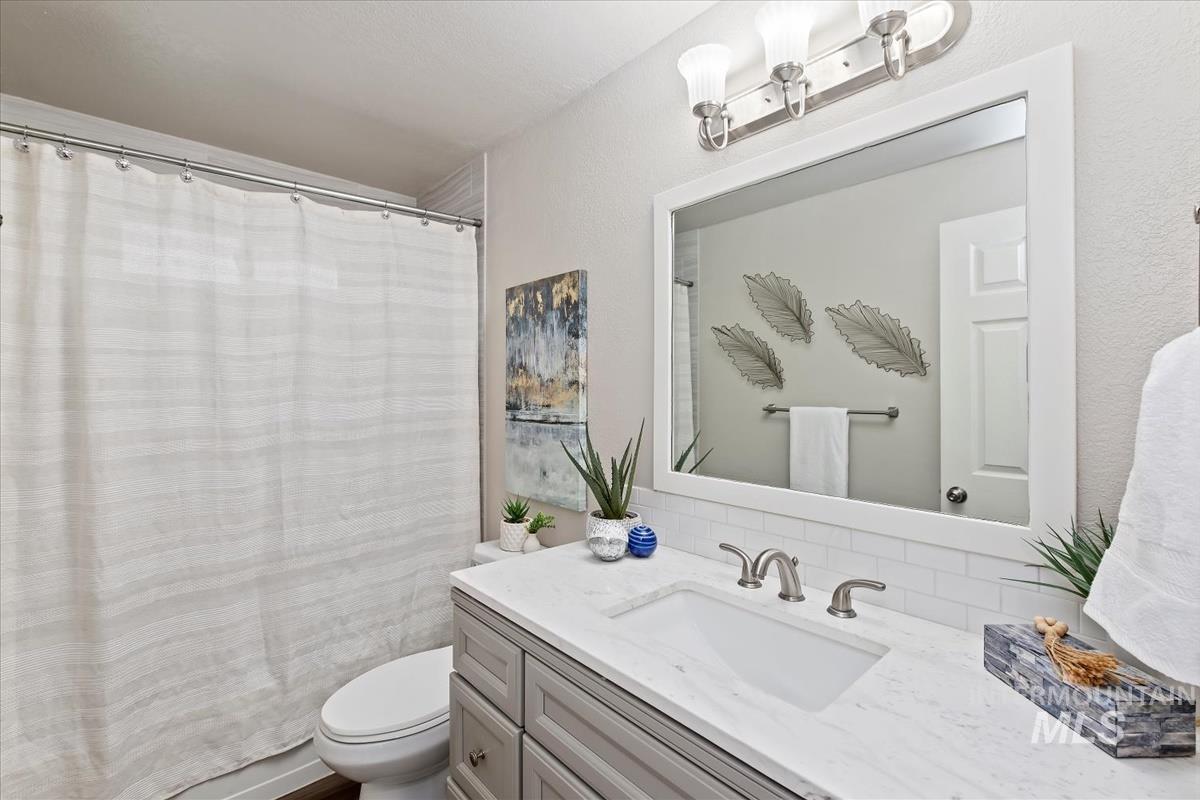 Bathroom featuring a shower with curtain and vanity