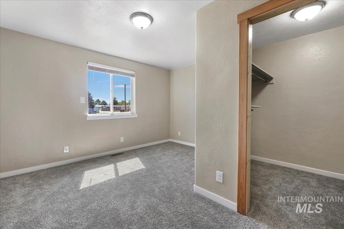 Unfurnished bedroom with carpet flooring and a textured wall