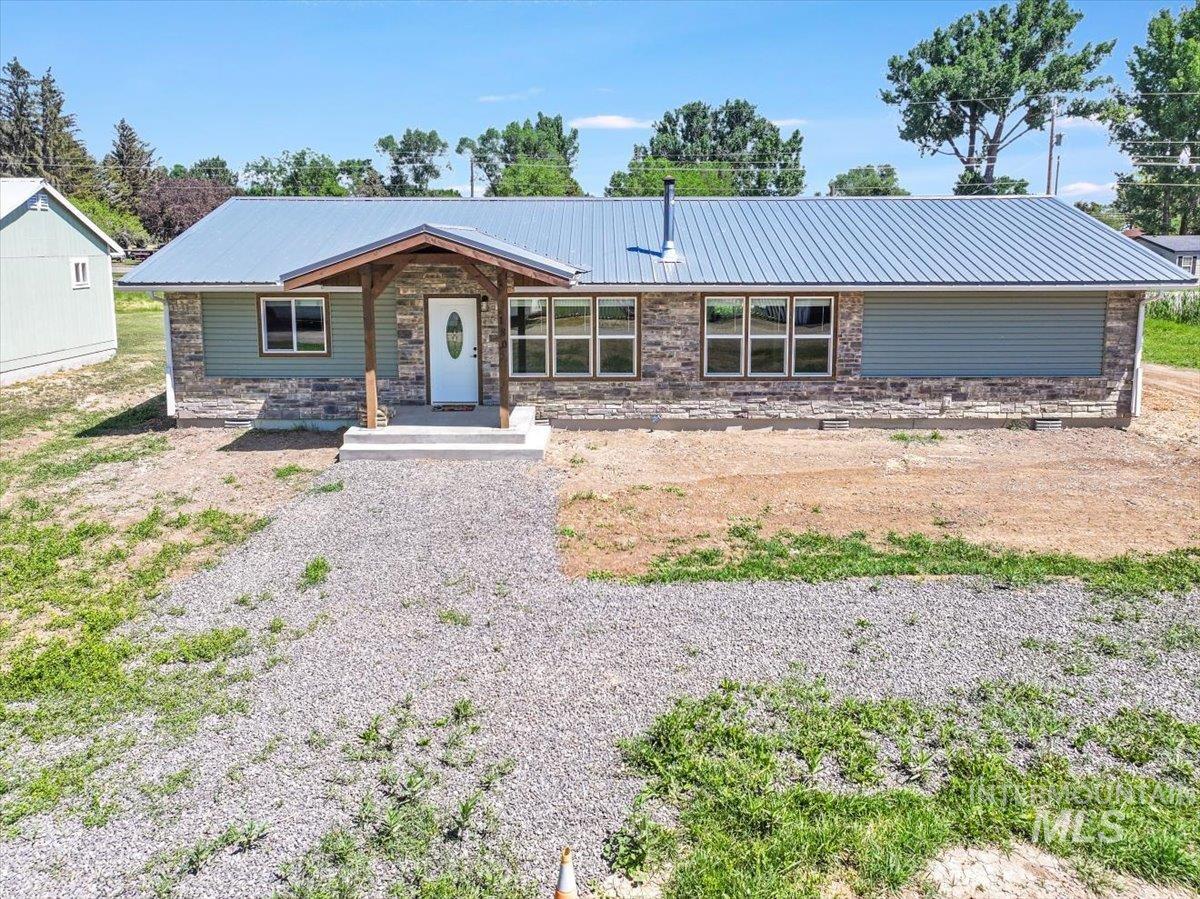 View of front facade with a metal roof and stone siding