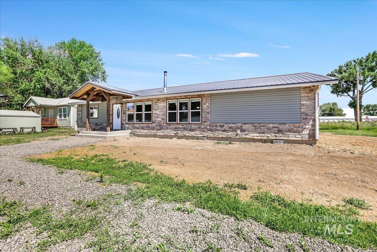 View of front of house featuring a metal roof, a porch, and crawl space