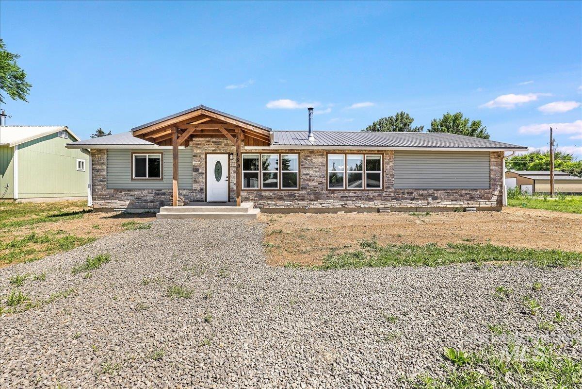 View of front of house featuring a metal roof and stone siding
