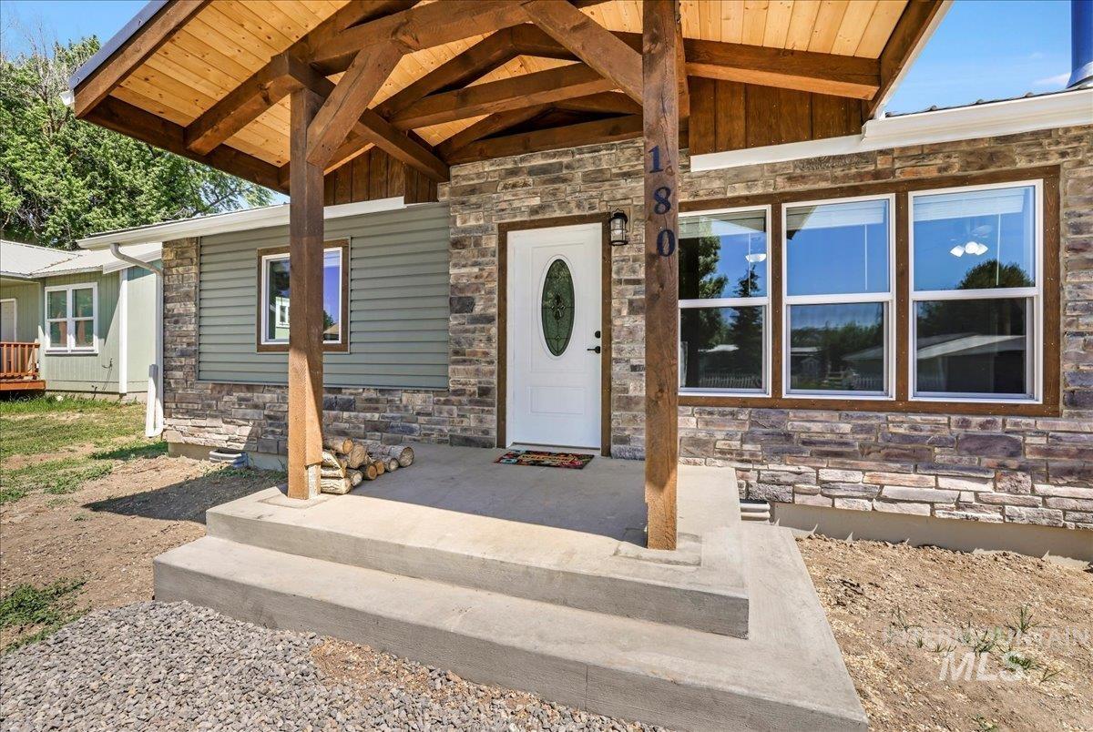 Doorway to property with stone siding and board and batten siding
