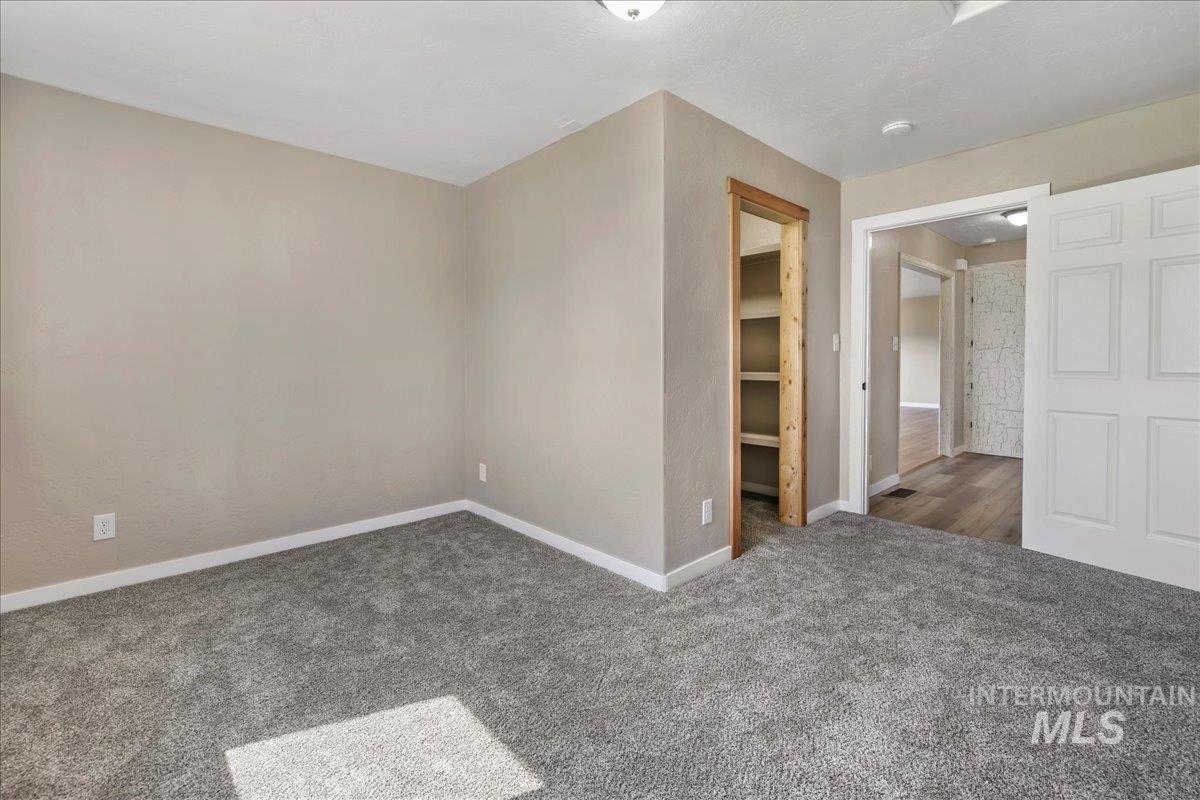 Carpeted empty room featuring baseboards