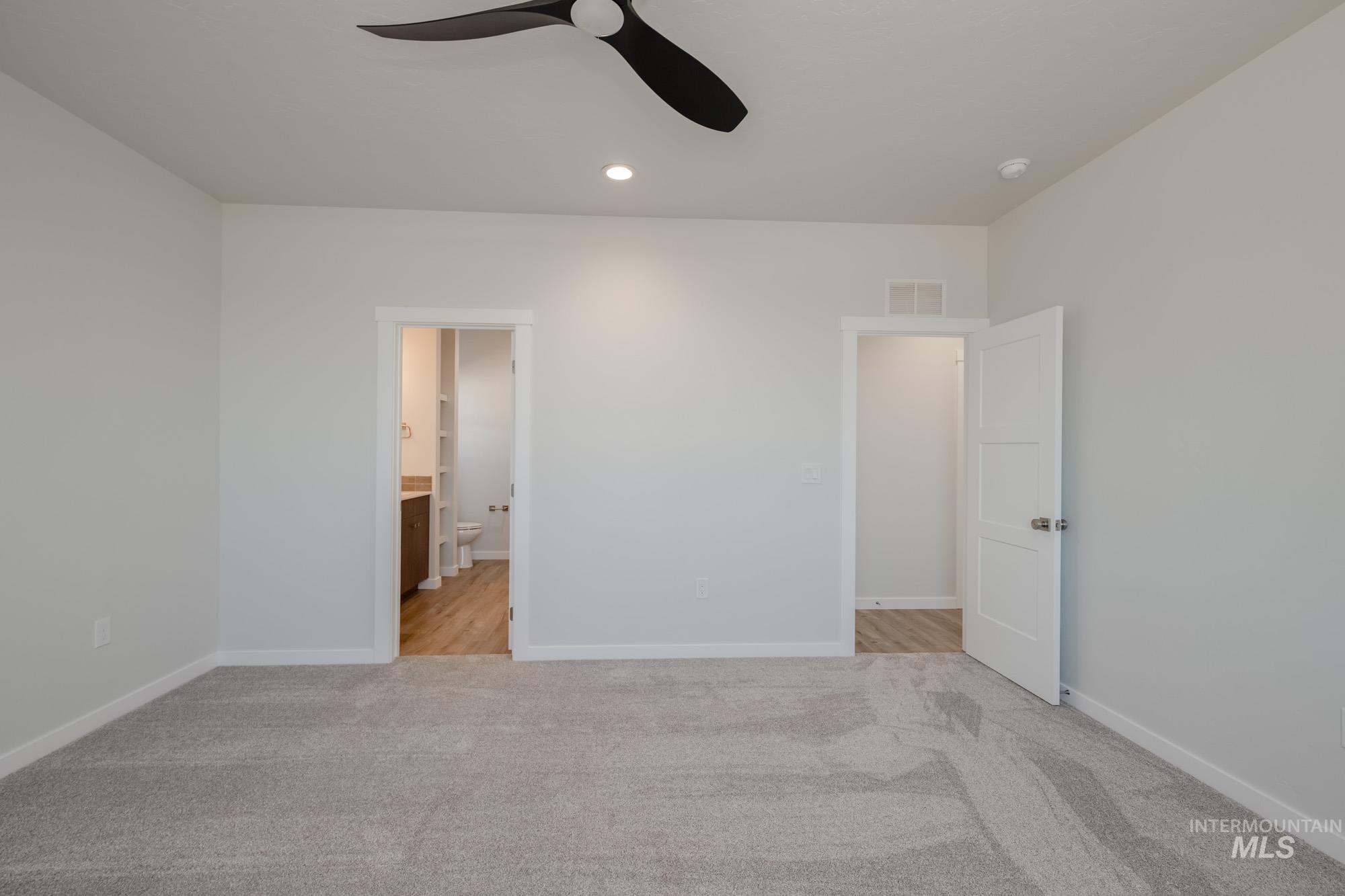 Unfurnished bedroom with light carpet, ceiling fan, connected bathroom, and recessed lighting