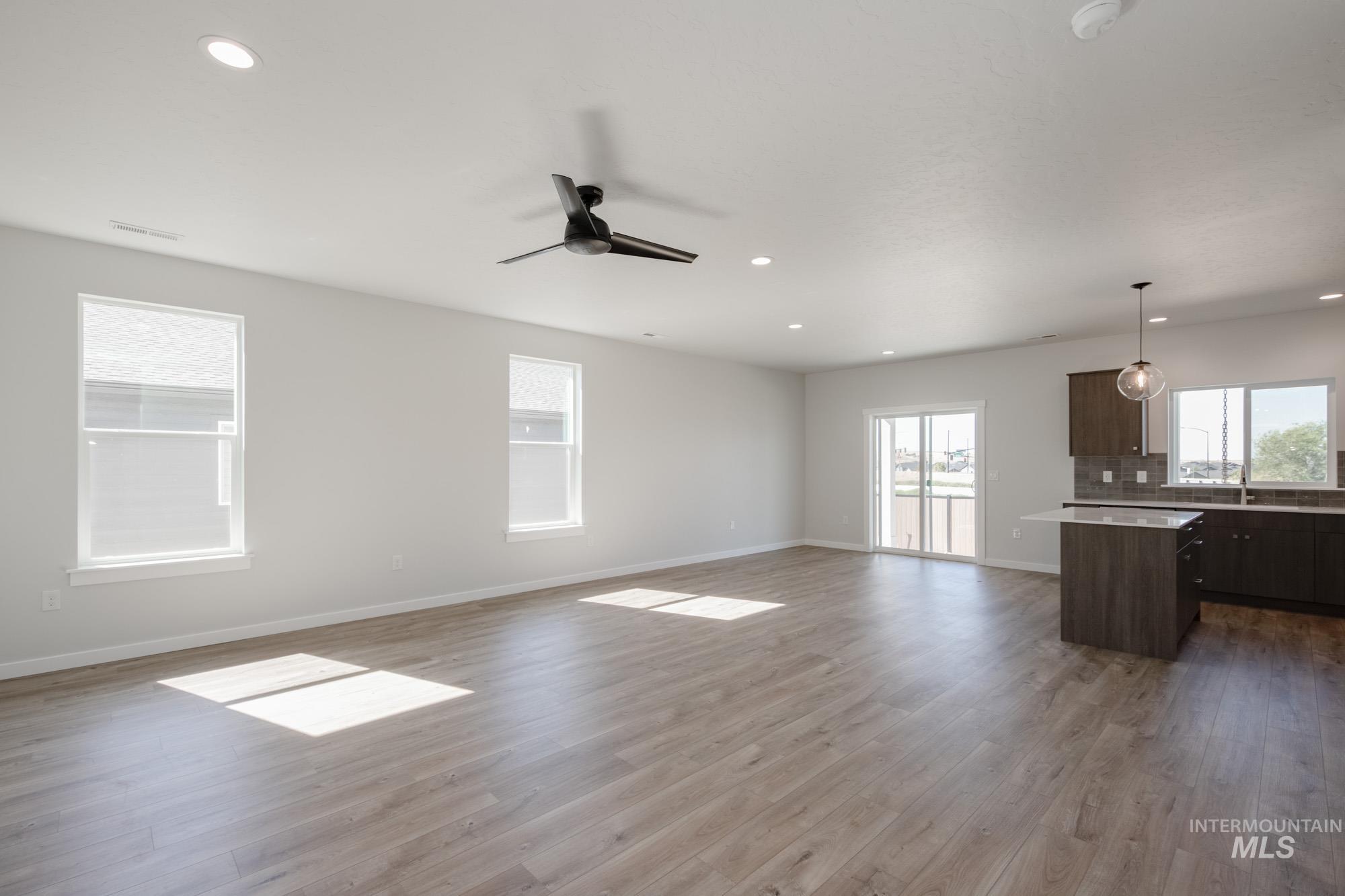 Unfurnished living room featuring recessed lighting, dark wood-style flooring, and a ceiling fan