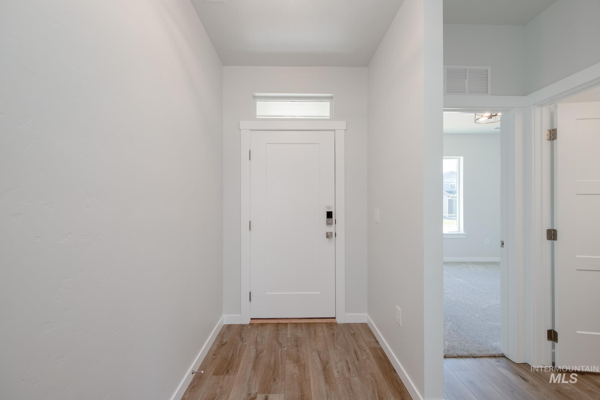 Foyer entrance featuring light wood-style flooring and baseboards