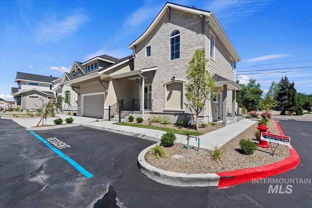 View of front of property with stone siding and uncovered parking